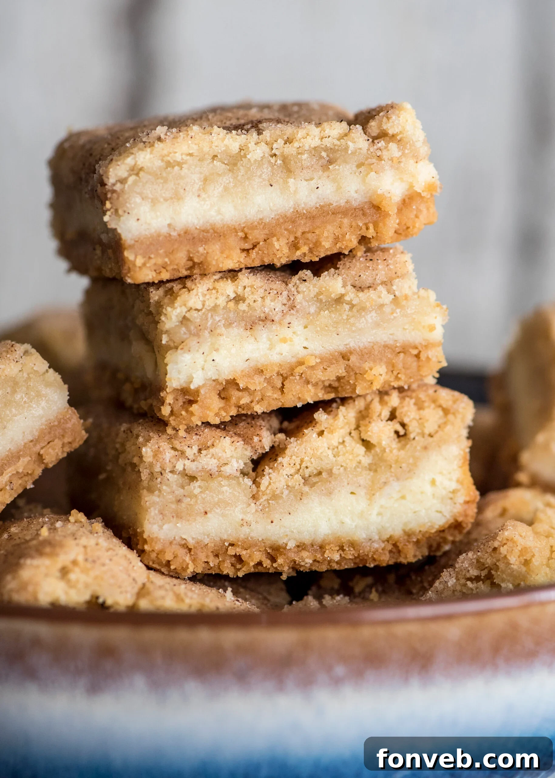 Snickerdoodle Cheesecake Bars stacked on a white plate