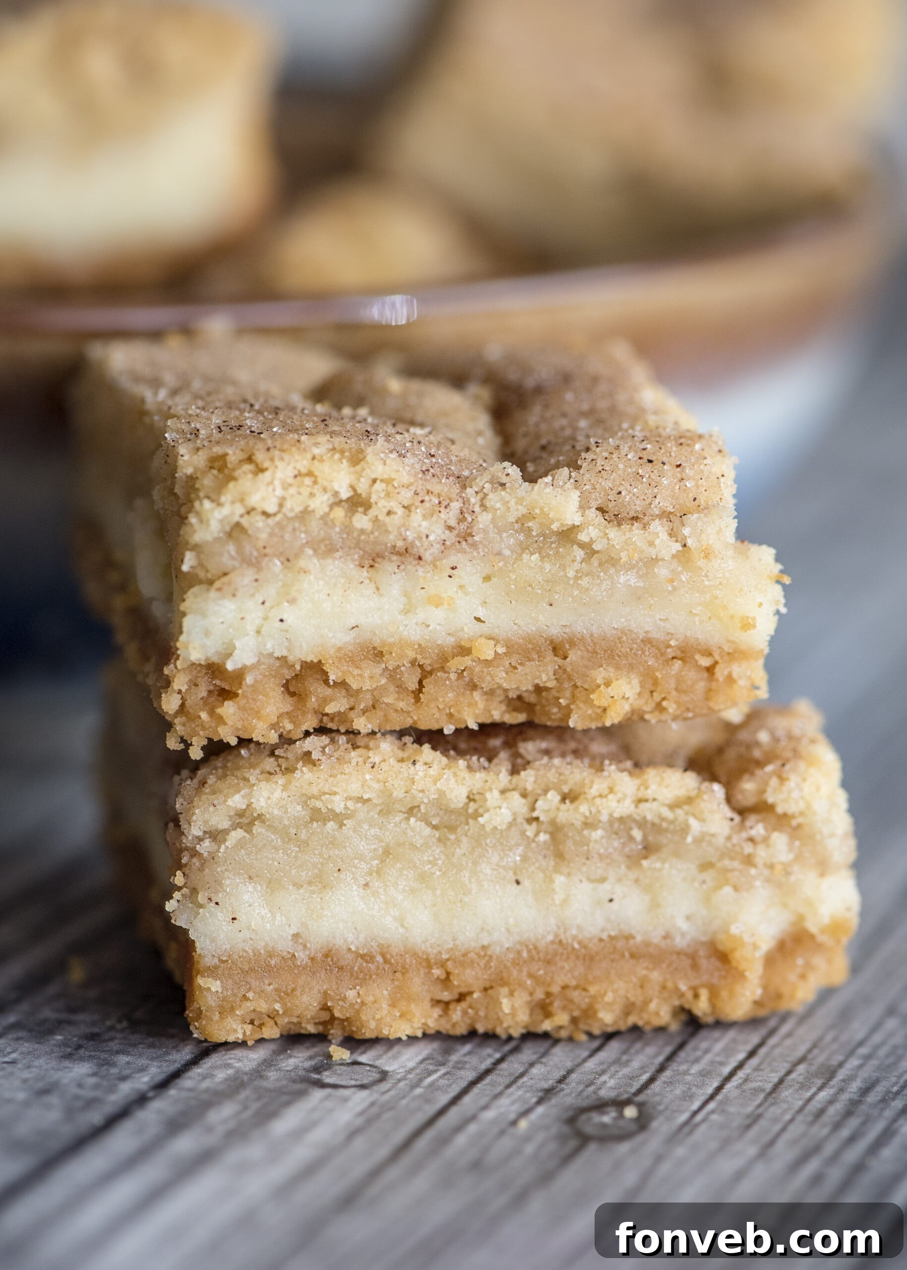 Snickerdoodle Cheesecake Bars arranged on a rustic wooden surface