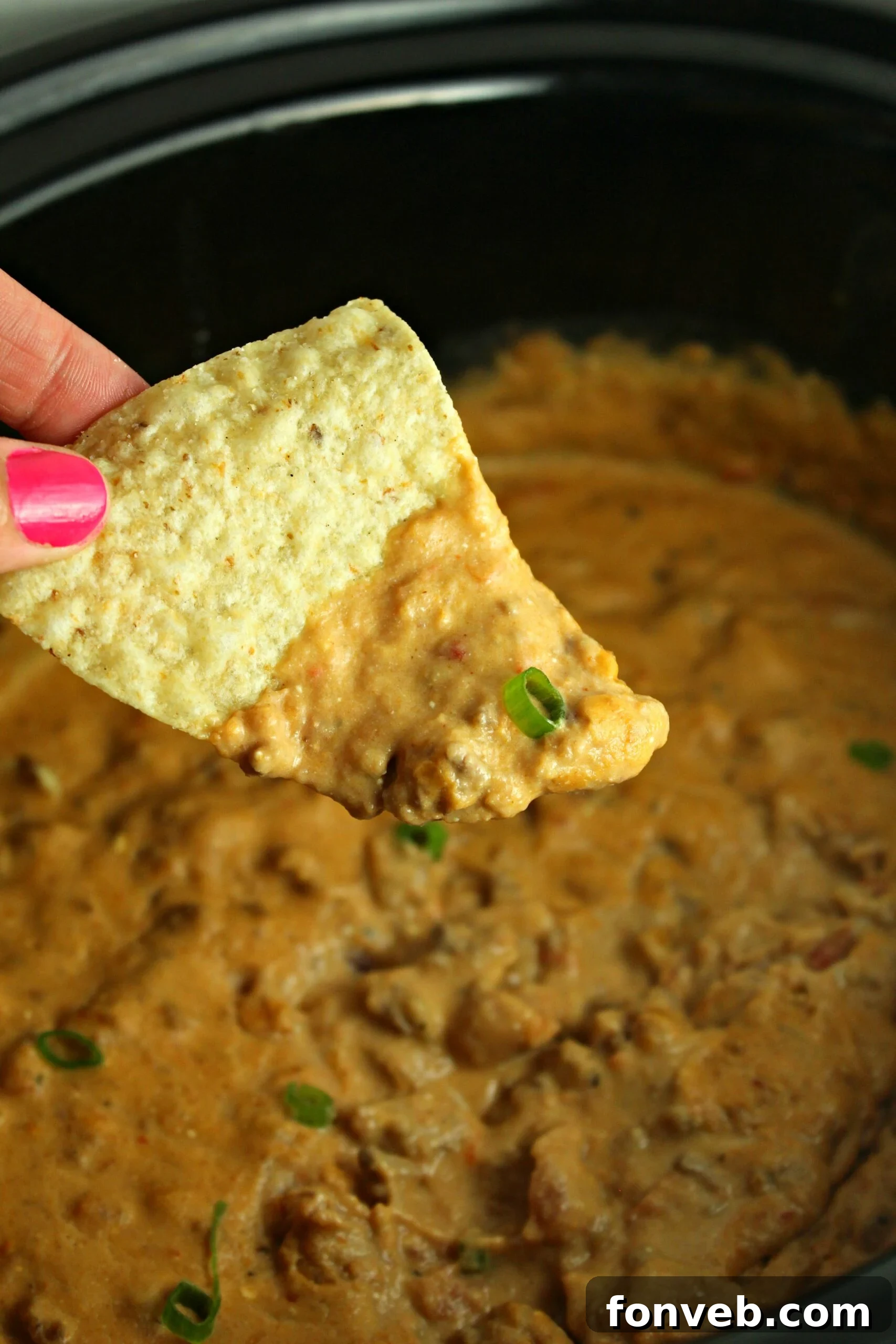 Close-up of a bubbling slow cooker taco dip with cheese