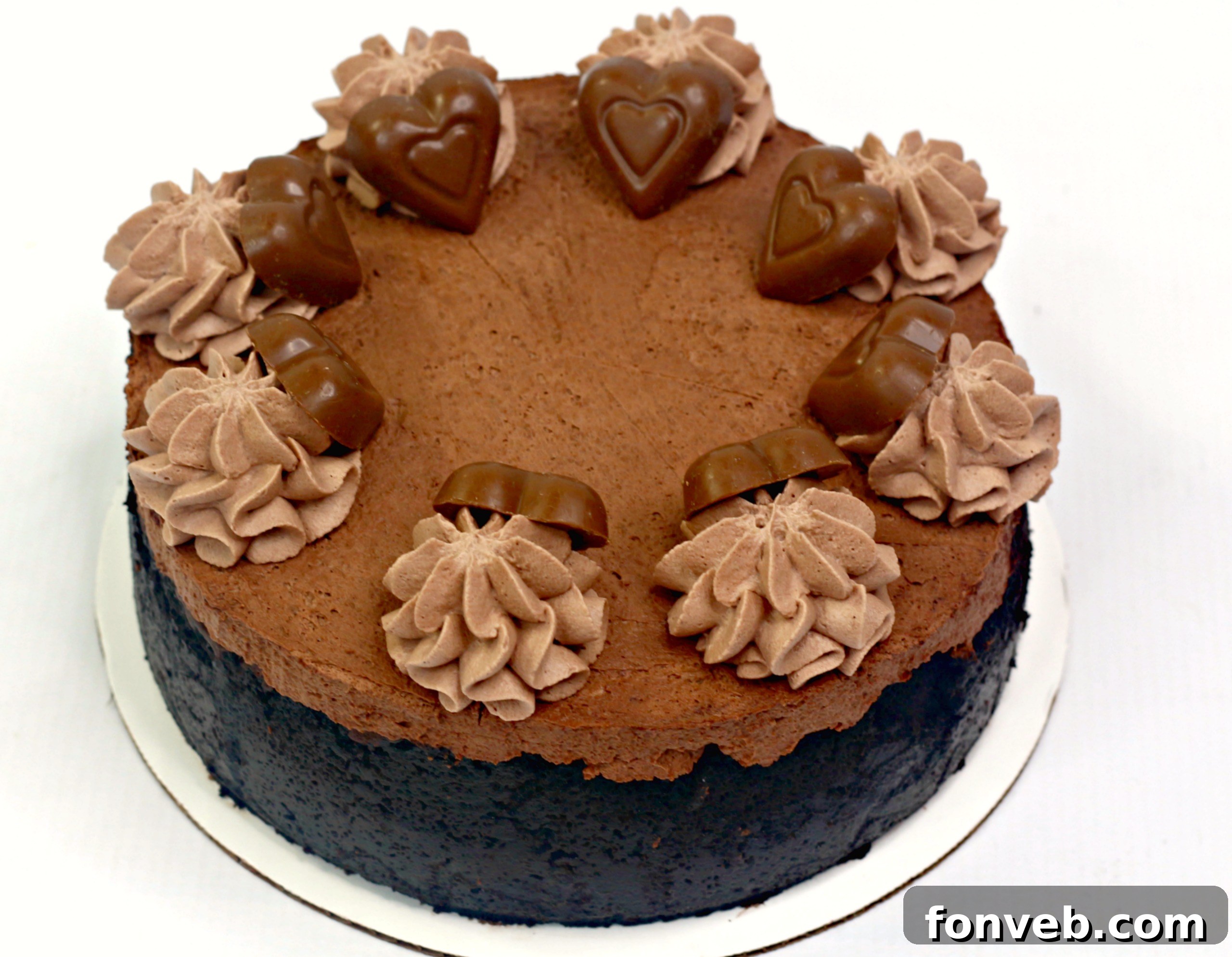 Overhead shot of the full Triple Chocolate Layered Godiva Cheesecake, adorned with chocolate hearts and a rich chocolate drizzle, ready to be sliced.