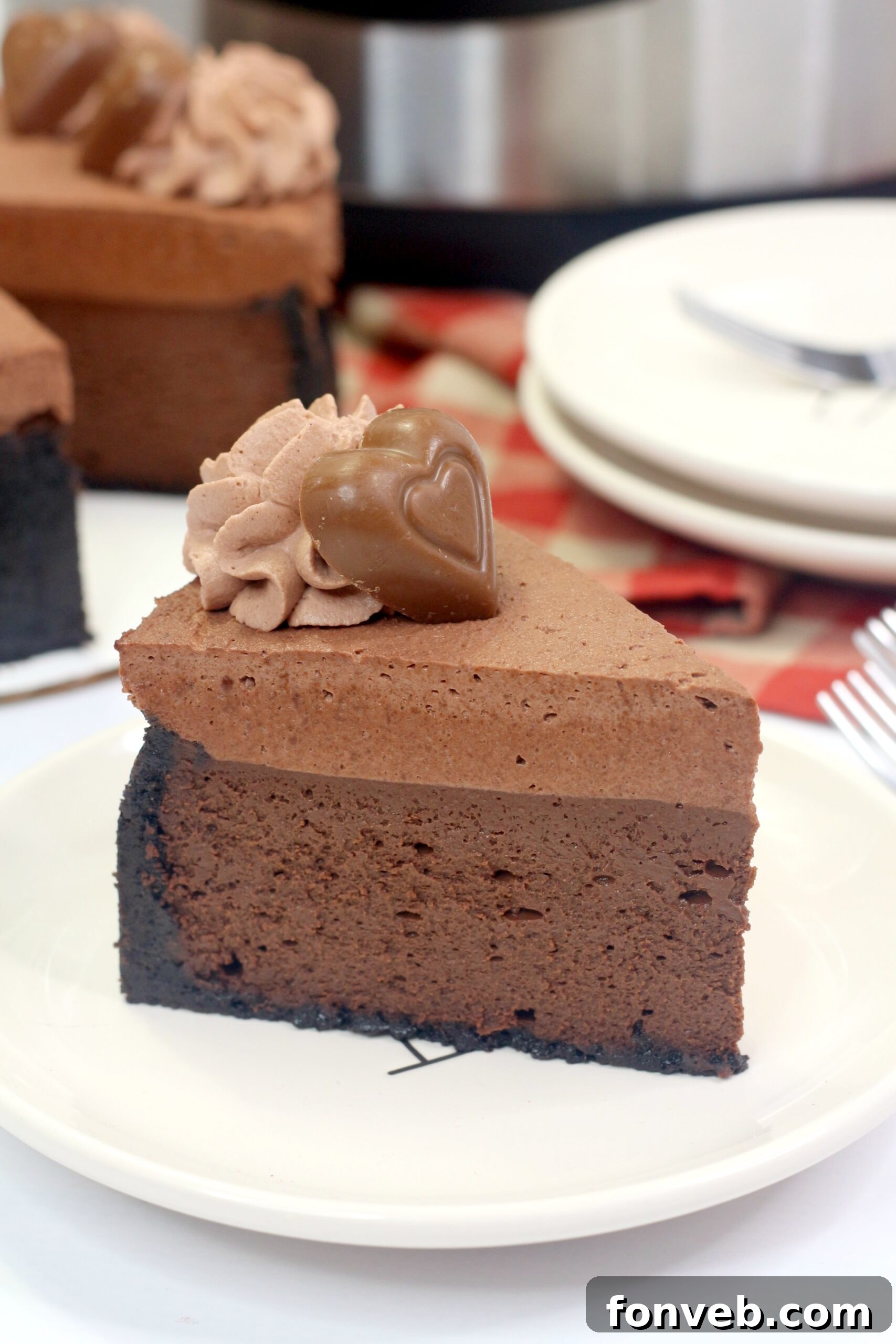 Top-down view of the cheesecake with a swirl of chocolate whipped cream and a single chocolate heart.