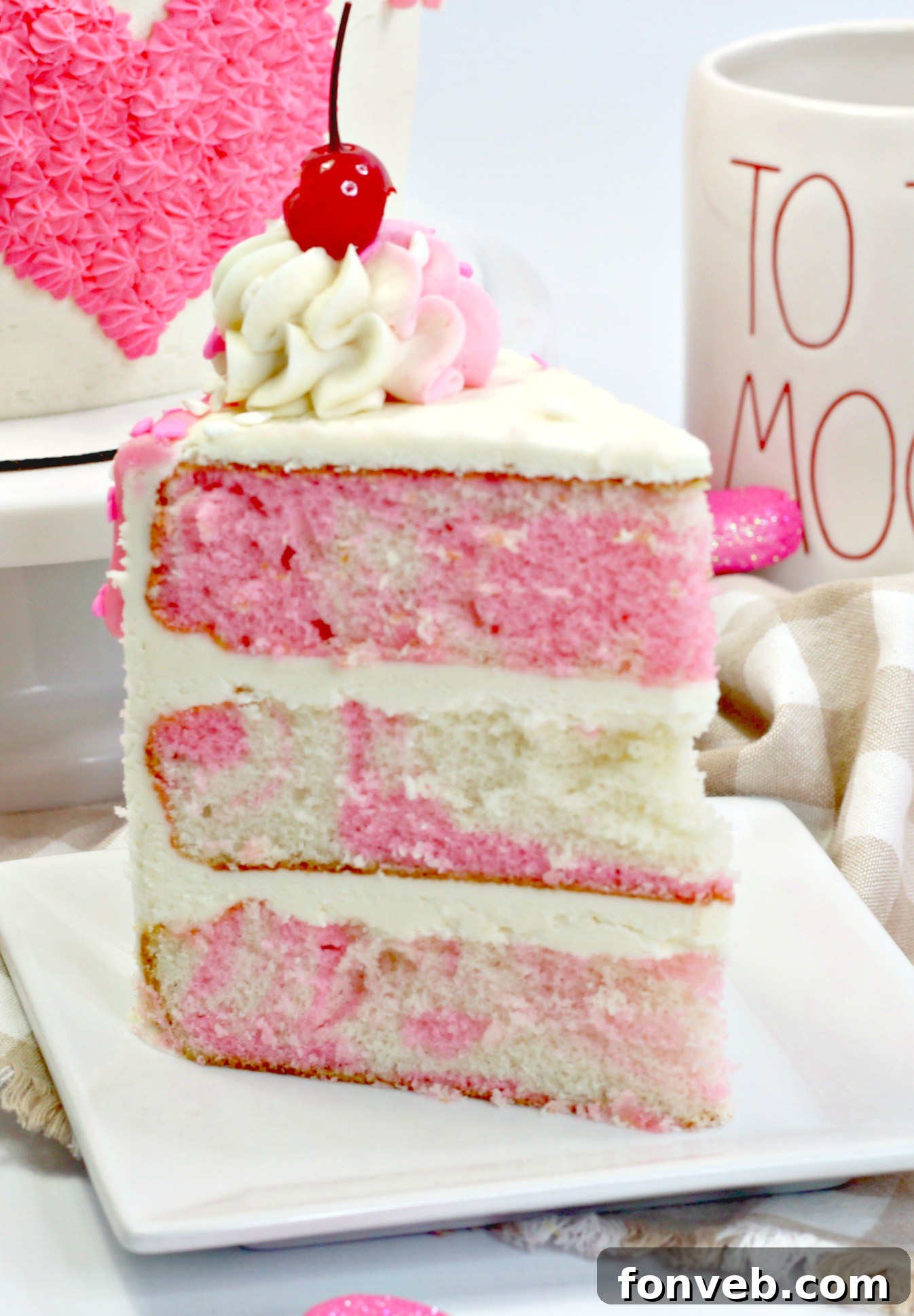 A side view of the tall, layered Valentine’s Day Love Cake showing the even frosting and festive sprinkles.