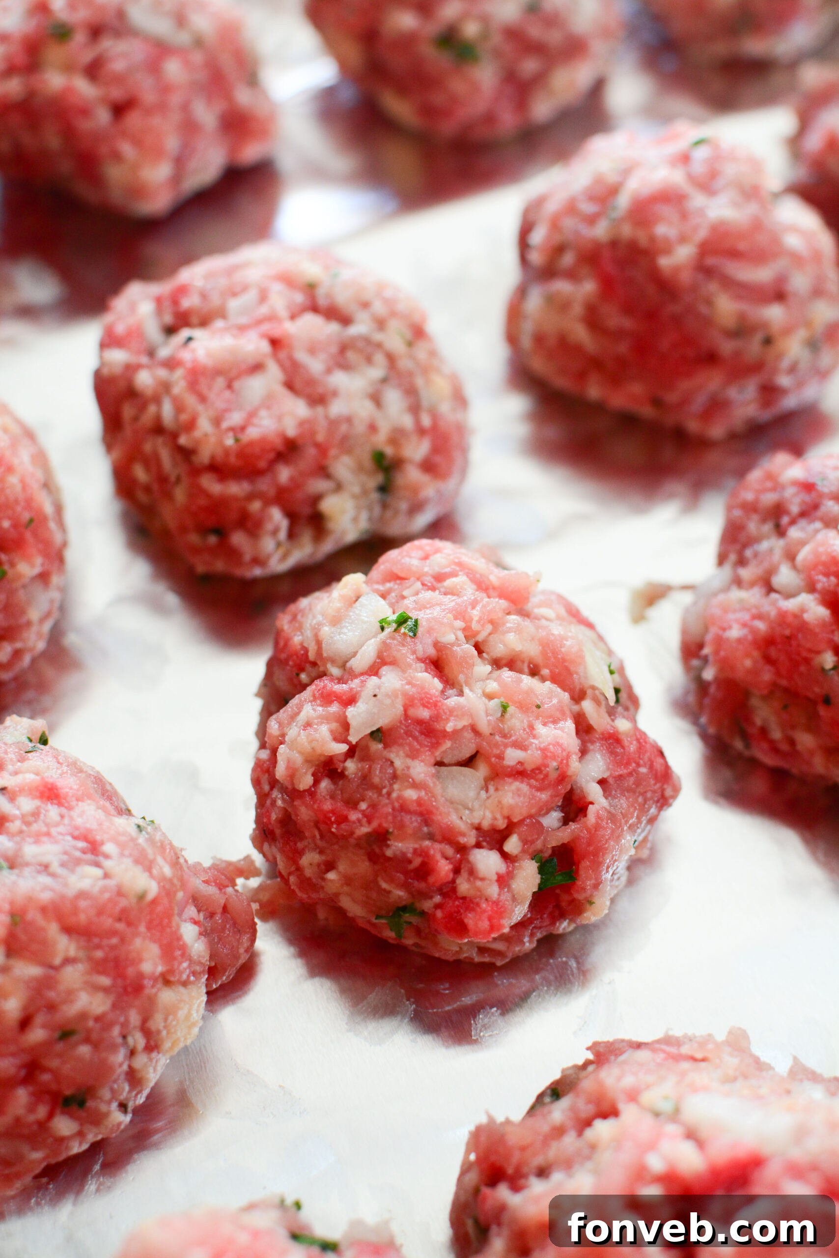 Close-up of baked Italian meatballs on a baking sheet, showcasing their perfect texture.