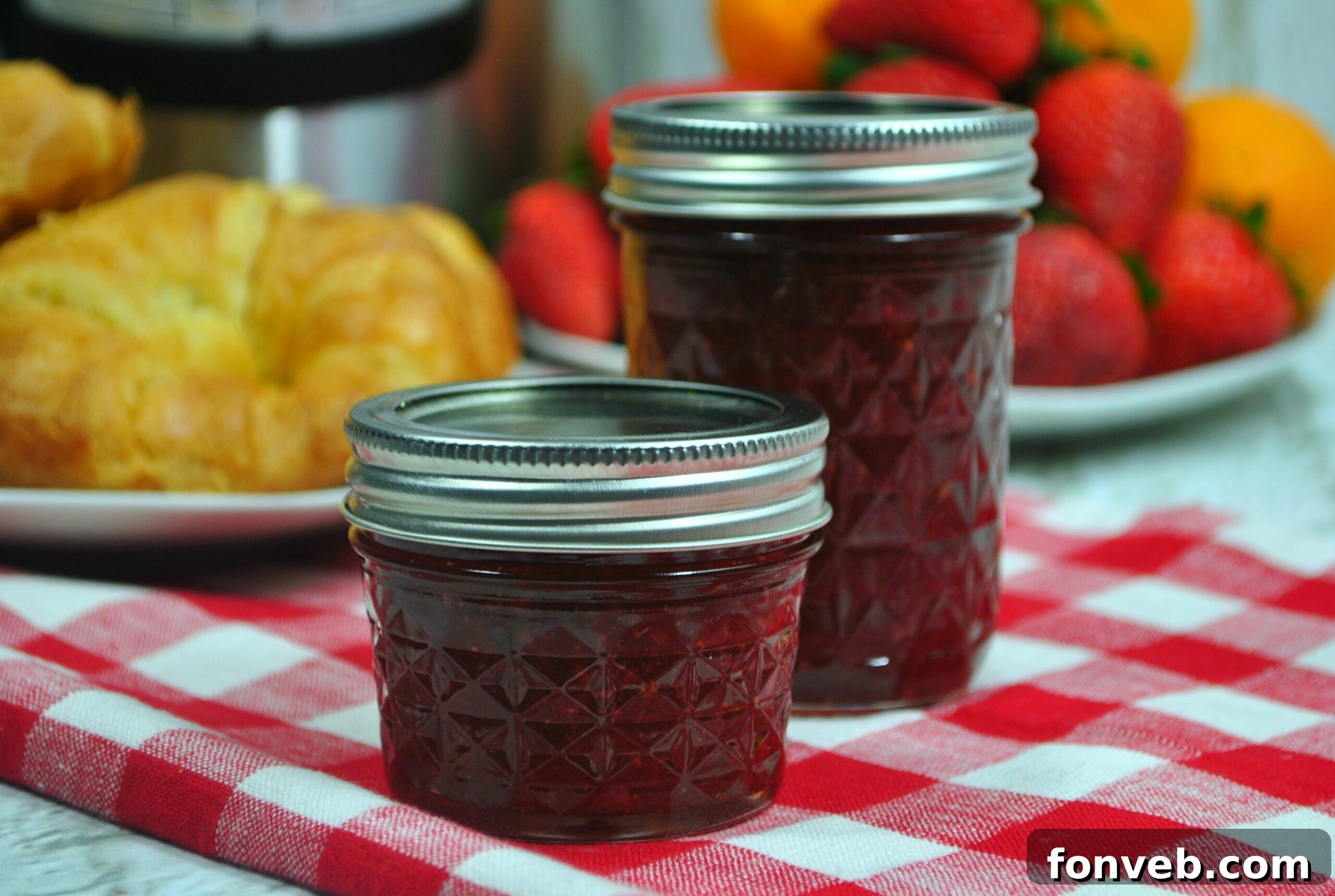 Delicious strawberry jam in a jar with fresh strawberries around it