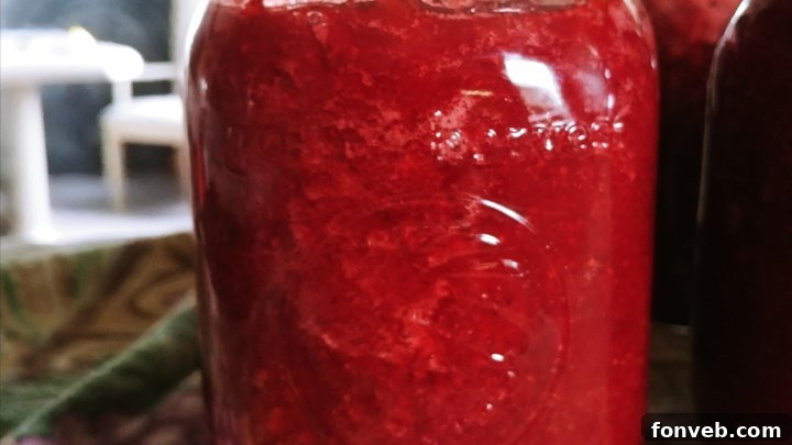 Strawberry jam being spooned onto toast