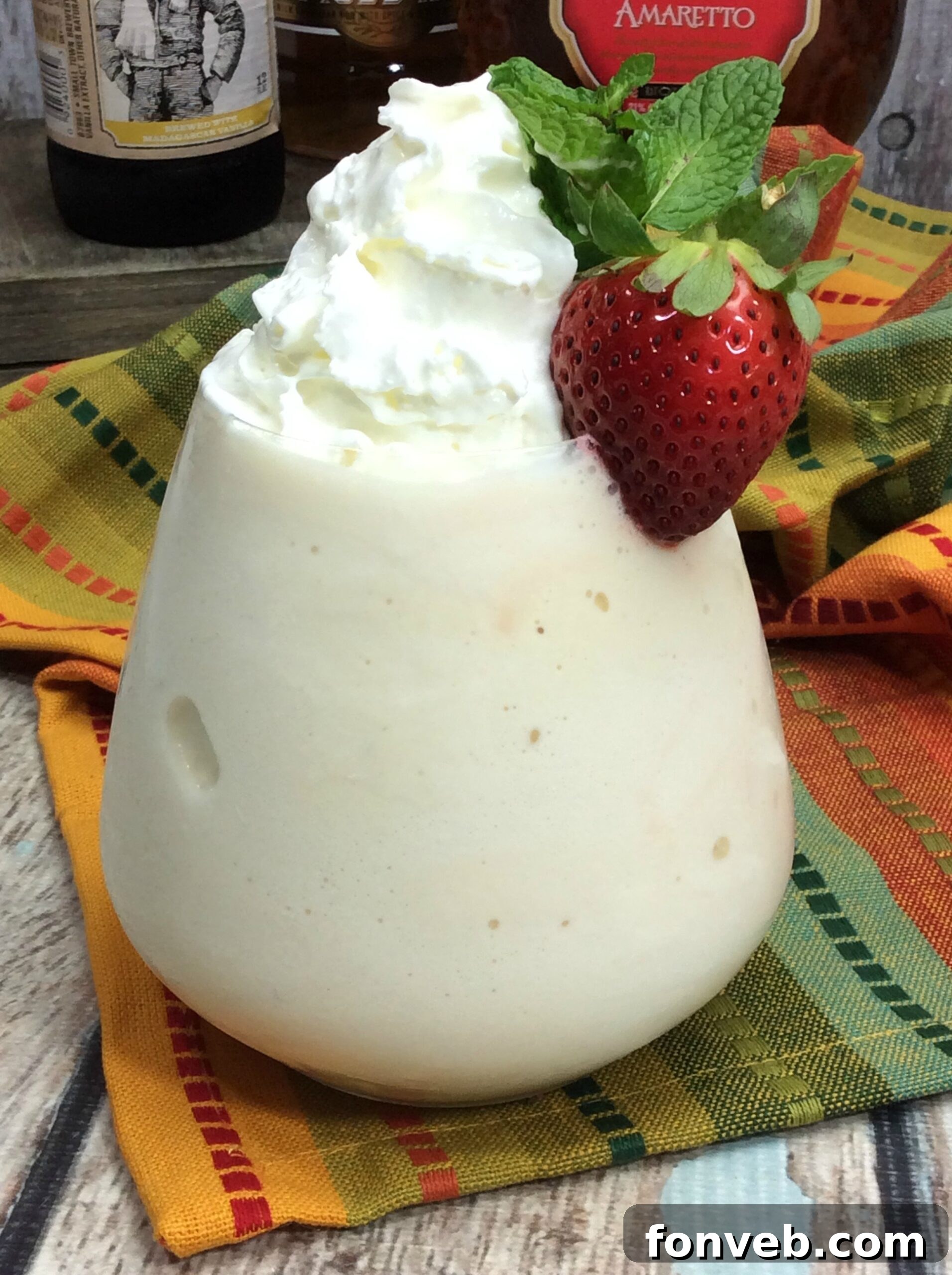 Two elegantly presented Painkiller Cocktails, garnished with fresh mint and strawberries, resting on a rustic wooden table, embodying tropical sophistication.