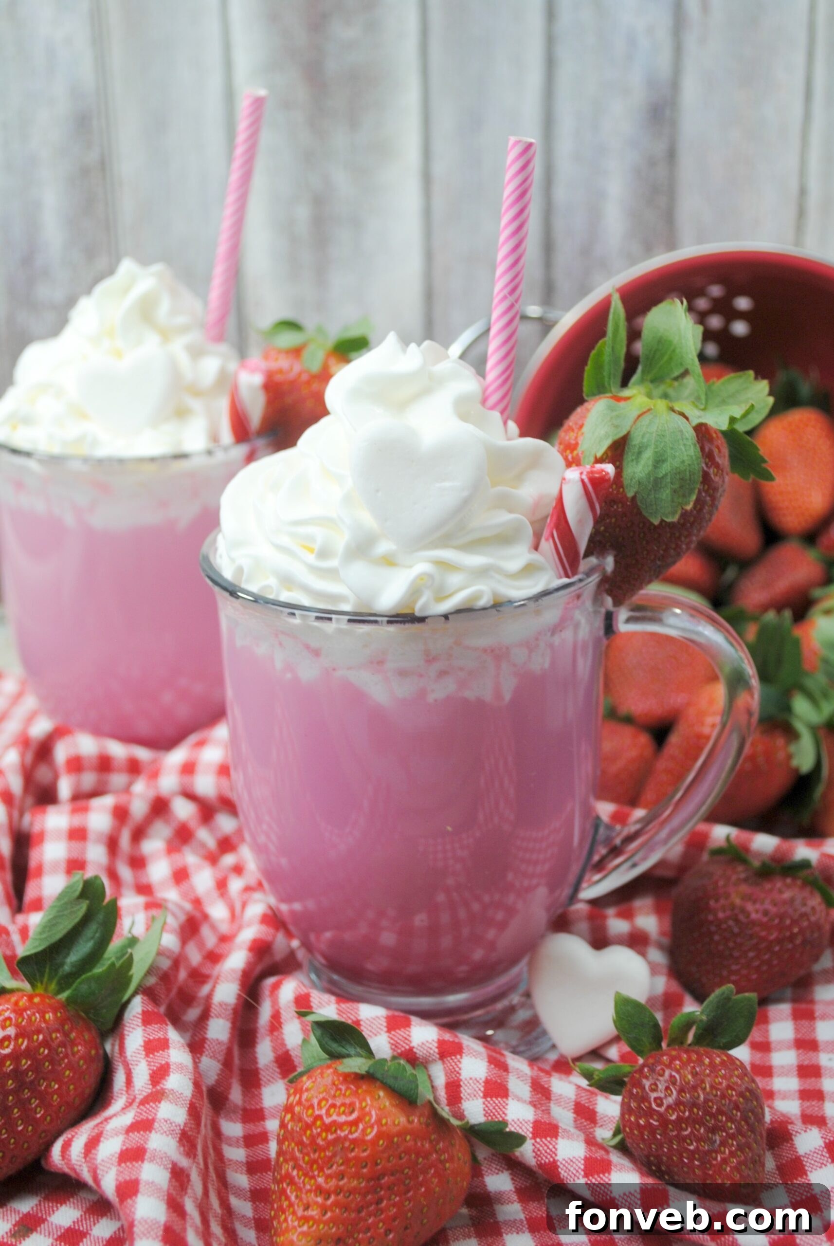 Close-up of Pink Velvet Hot Chocolate with a heart-shaped strawberry garnish and a gentle swirl of whipped cream.