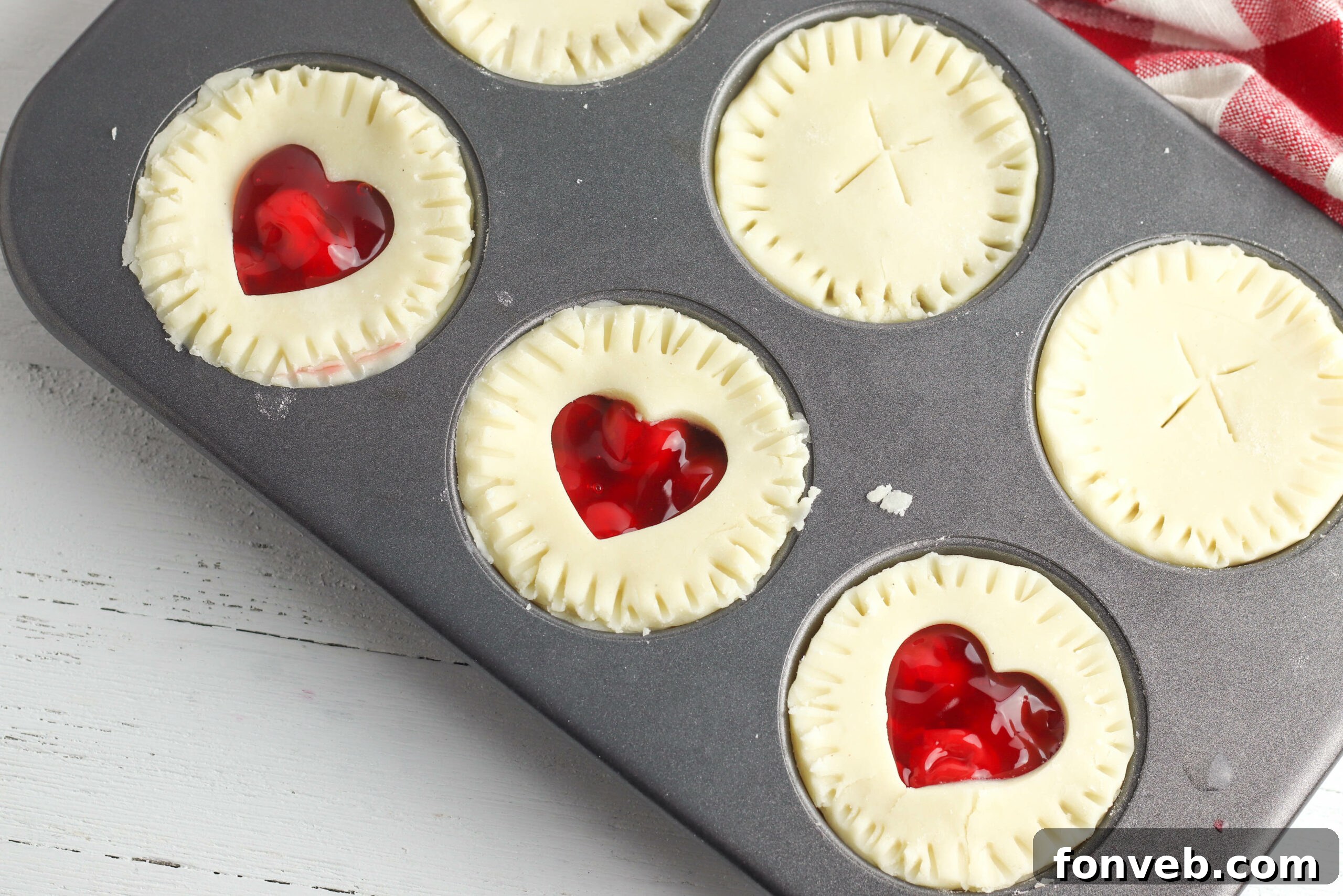 A close-up of a mini cherry pie with a heart-shaped cutout on top, perfect for Valentine's Day.
