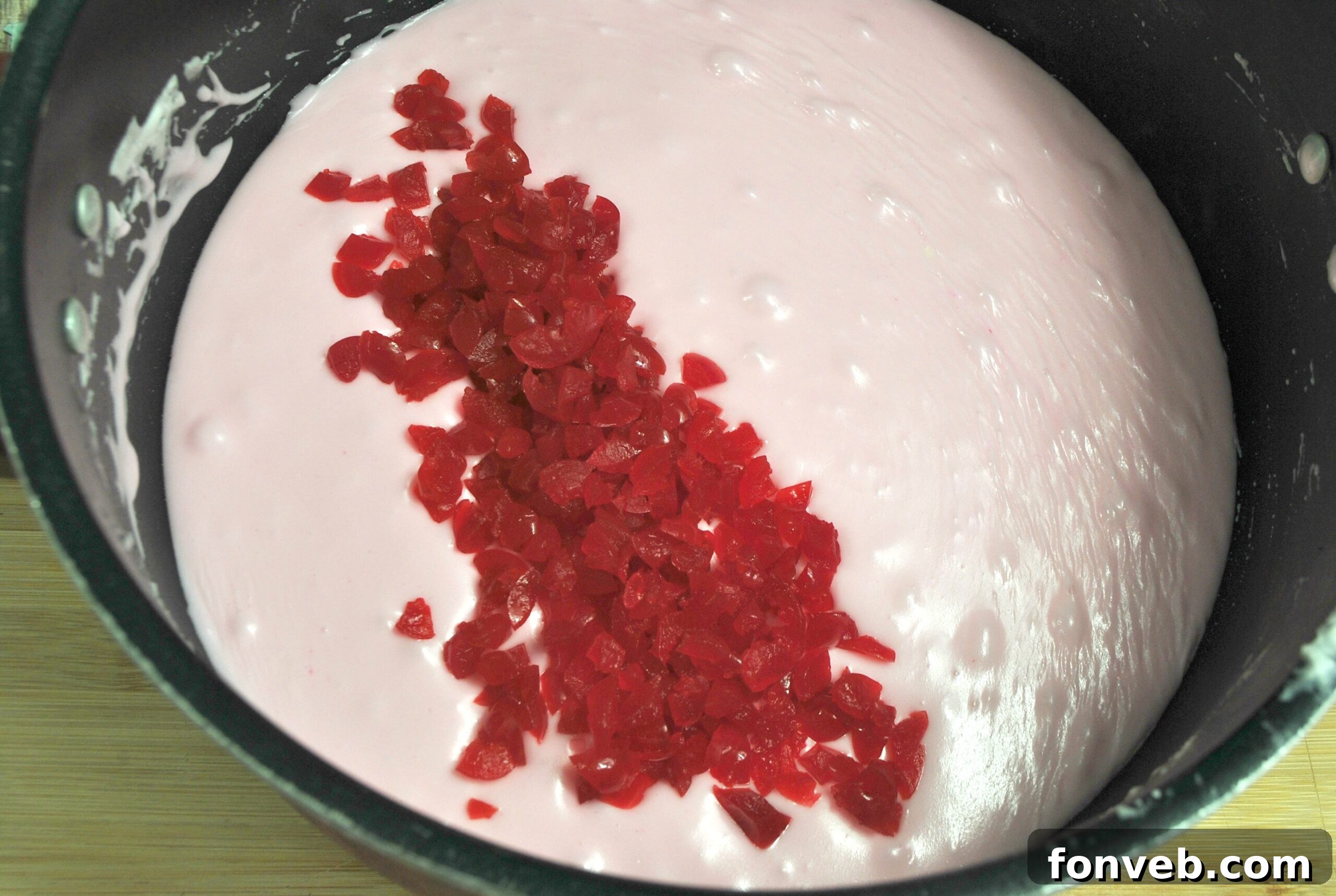 A tray of cherry fudge squares, some stacked, highlighting the vibrant pink color and rich texture.