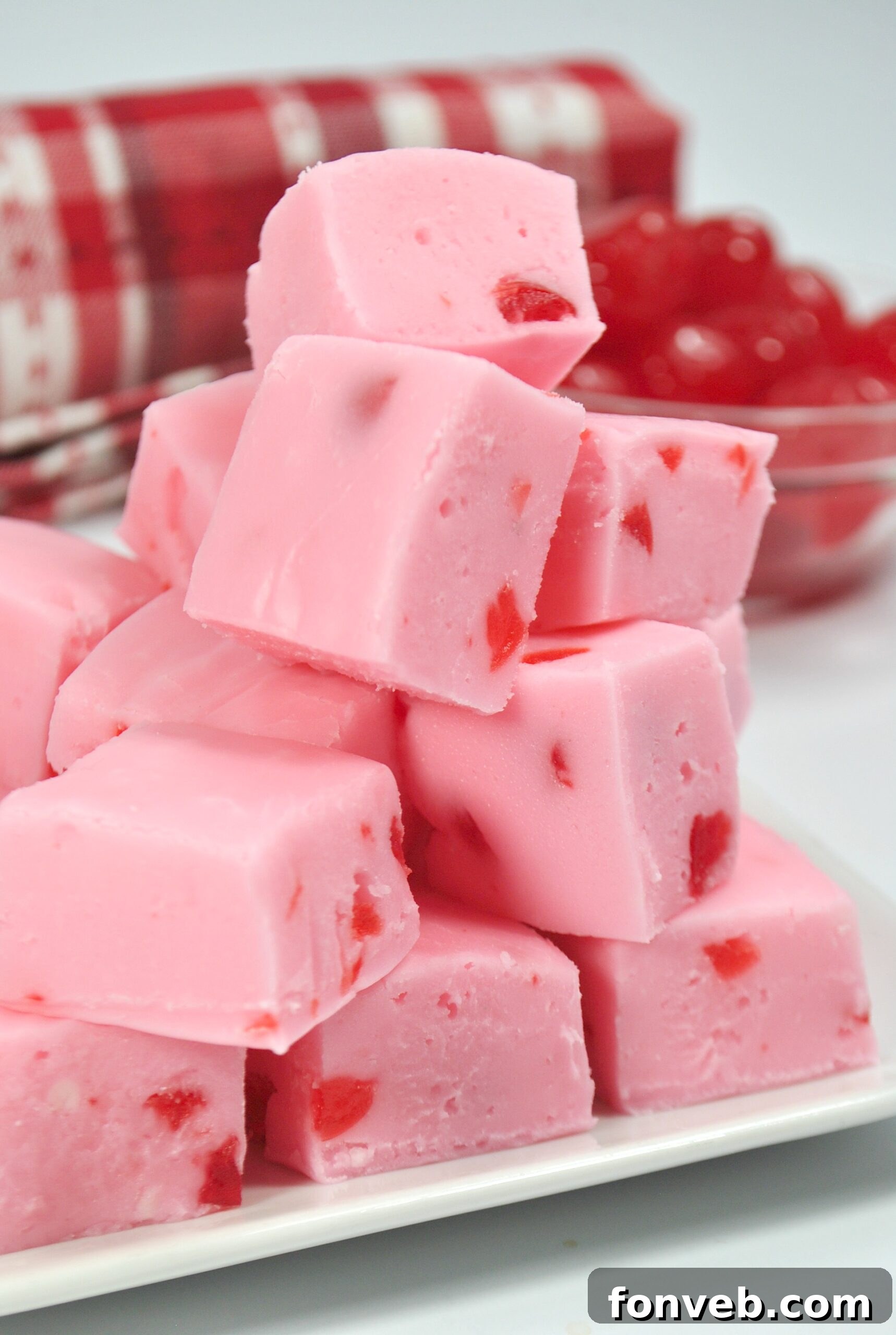 A single piece of cherry fudge, perfectly sliced, resting on a white plate with a subtle background blur.