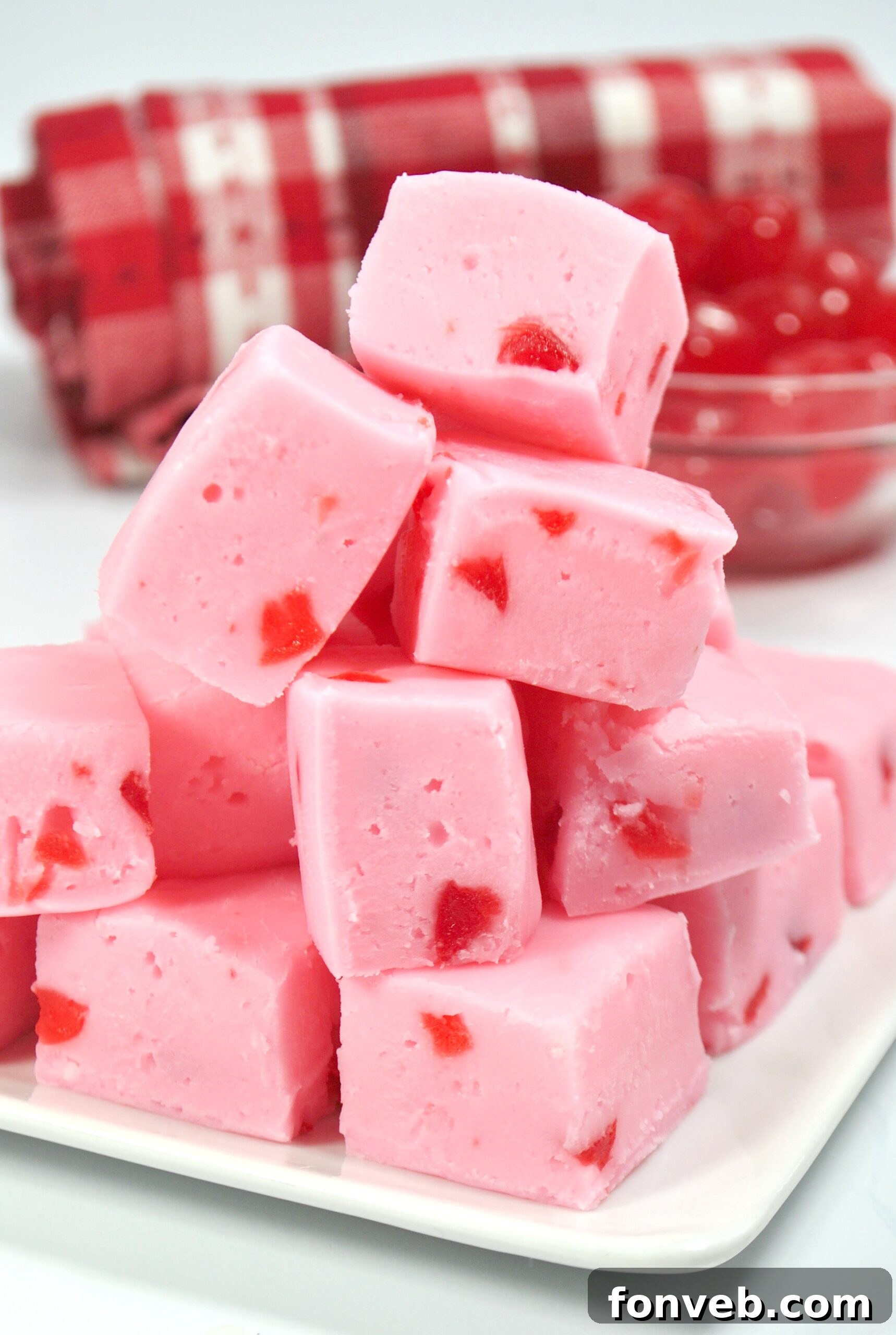 Several pieces of cherry fudge arranged artistically on a light-colored background, emphasizing their homemade appeal.