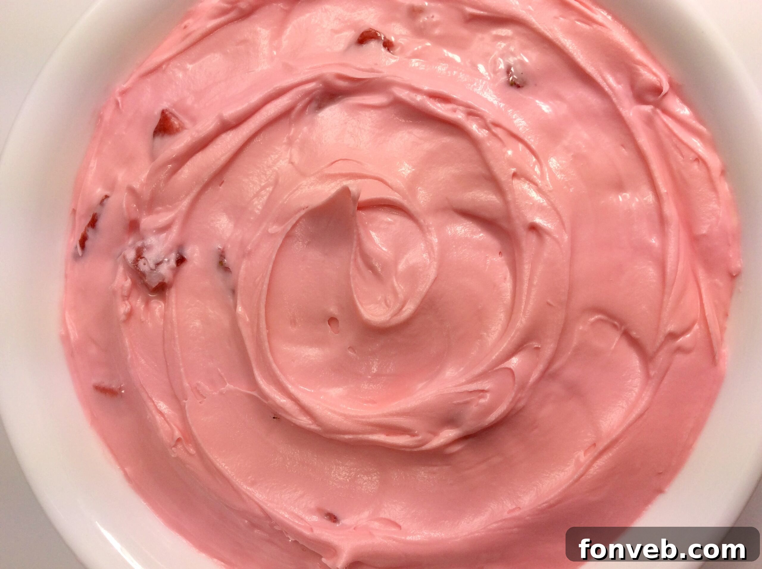 Another perspective of the strawberry buttercream frosted cake, showcasing its texture.