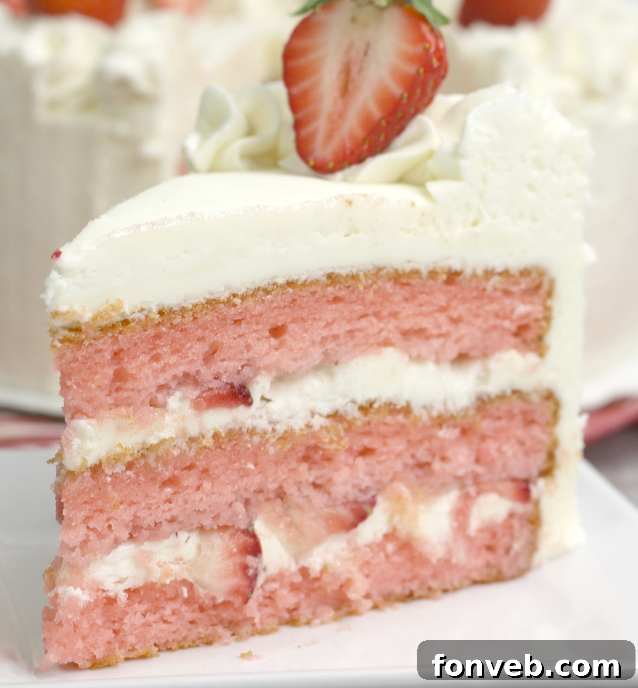 Moscato Infused Strawberry Cake with Cream Cheese Buttercream 3 A whole Strawberry Moscato Cake with Cream Cheese Buttercream Frosting, garnished with fresh strawberries, ready to be sliced.