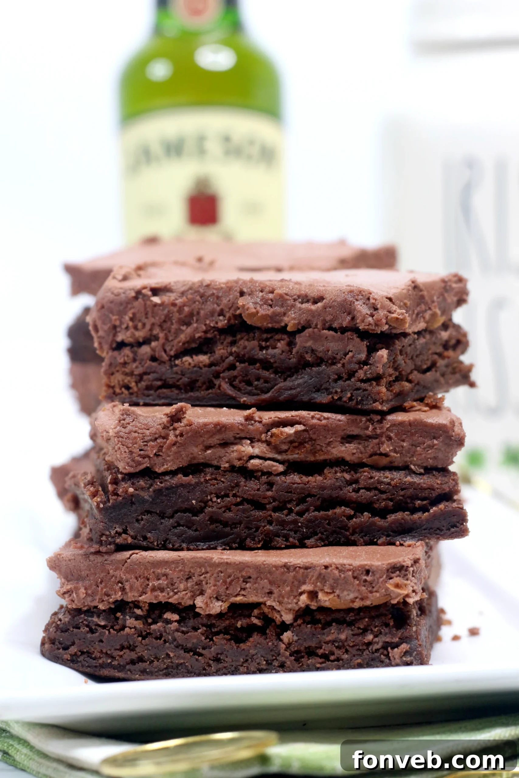 A close-up shot of Irish Fudge Brownies stacked, showcasing the decadent frosting