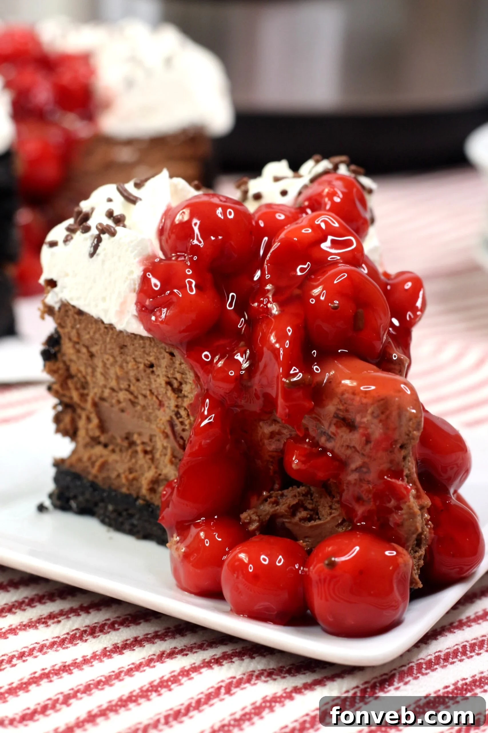 Rich Black Forest Chocolate Cheesecake topped with whipped cream and cherries