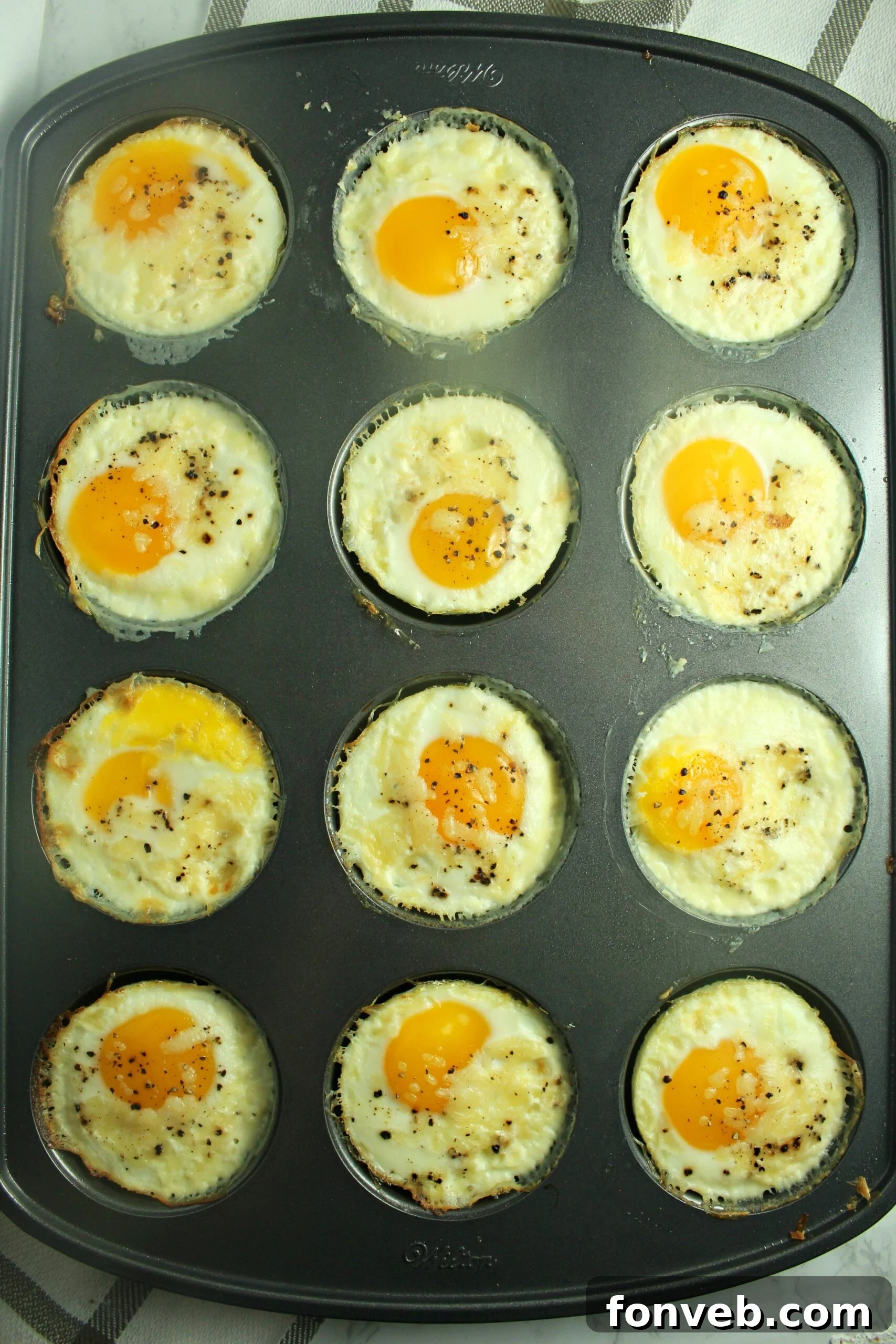 The Perfect Oven Fried Eggs 5 Muffin tin filled with baked fried eggs