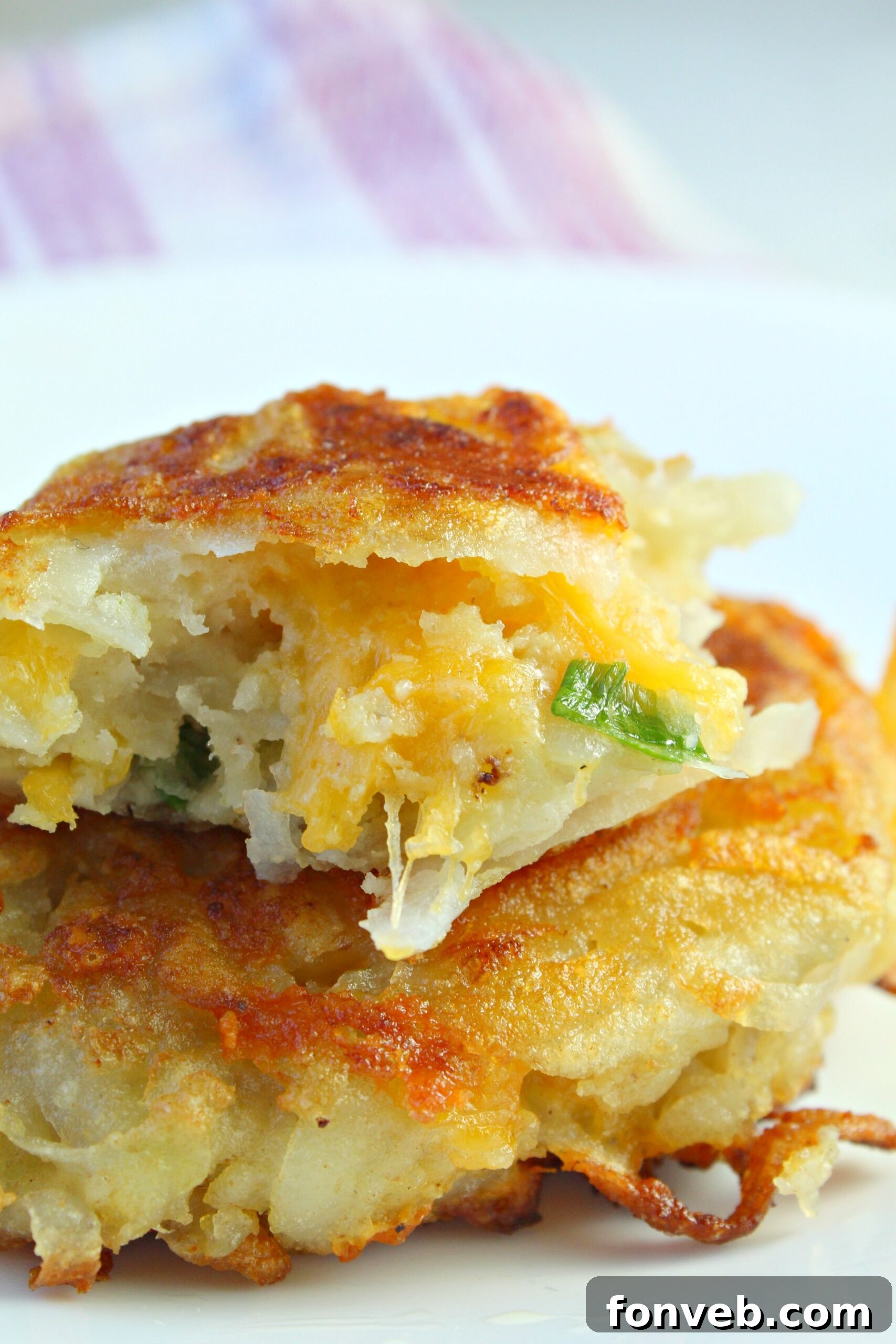 Close-up of a hash brown patty with visible melted cheese pull.