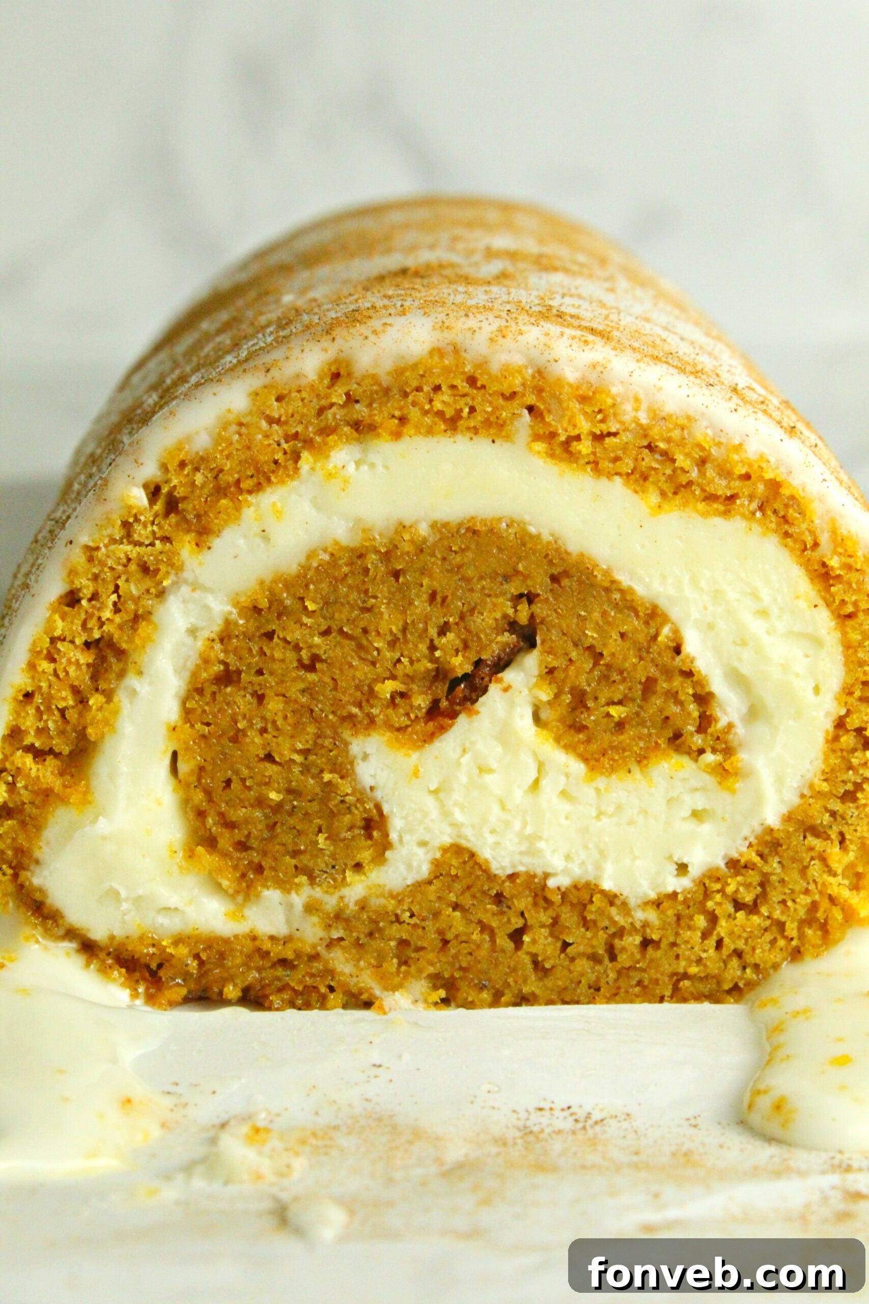A close-up detail of the rolled pumpkin cake, highlighting the texture.