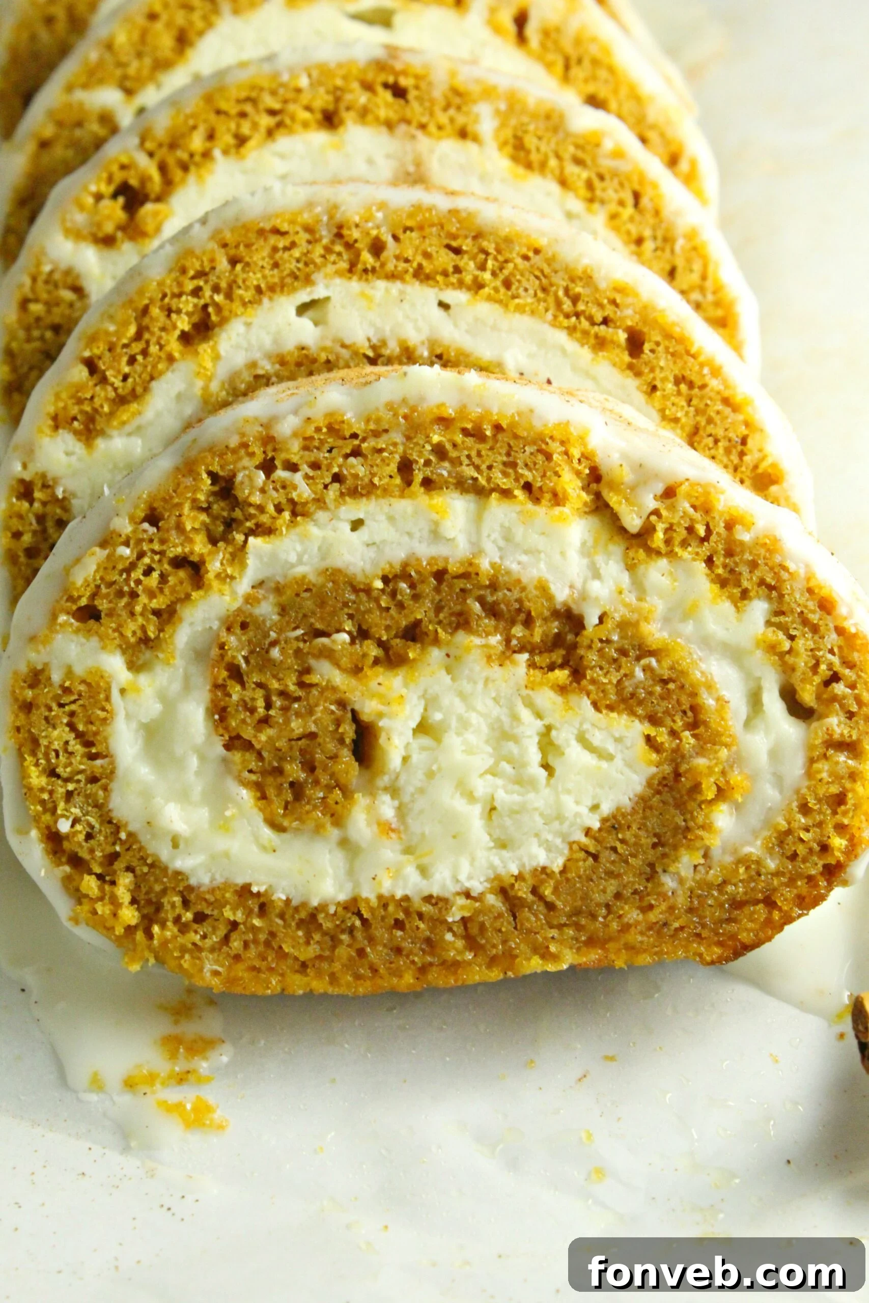 A top-down view of the pumpkin cake roll, dusted with powdered sugar.