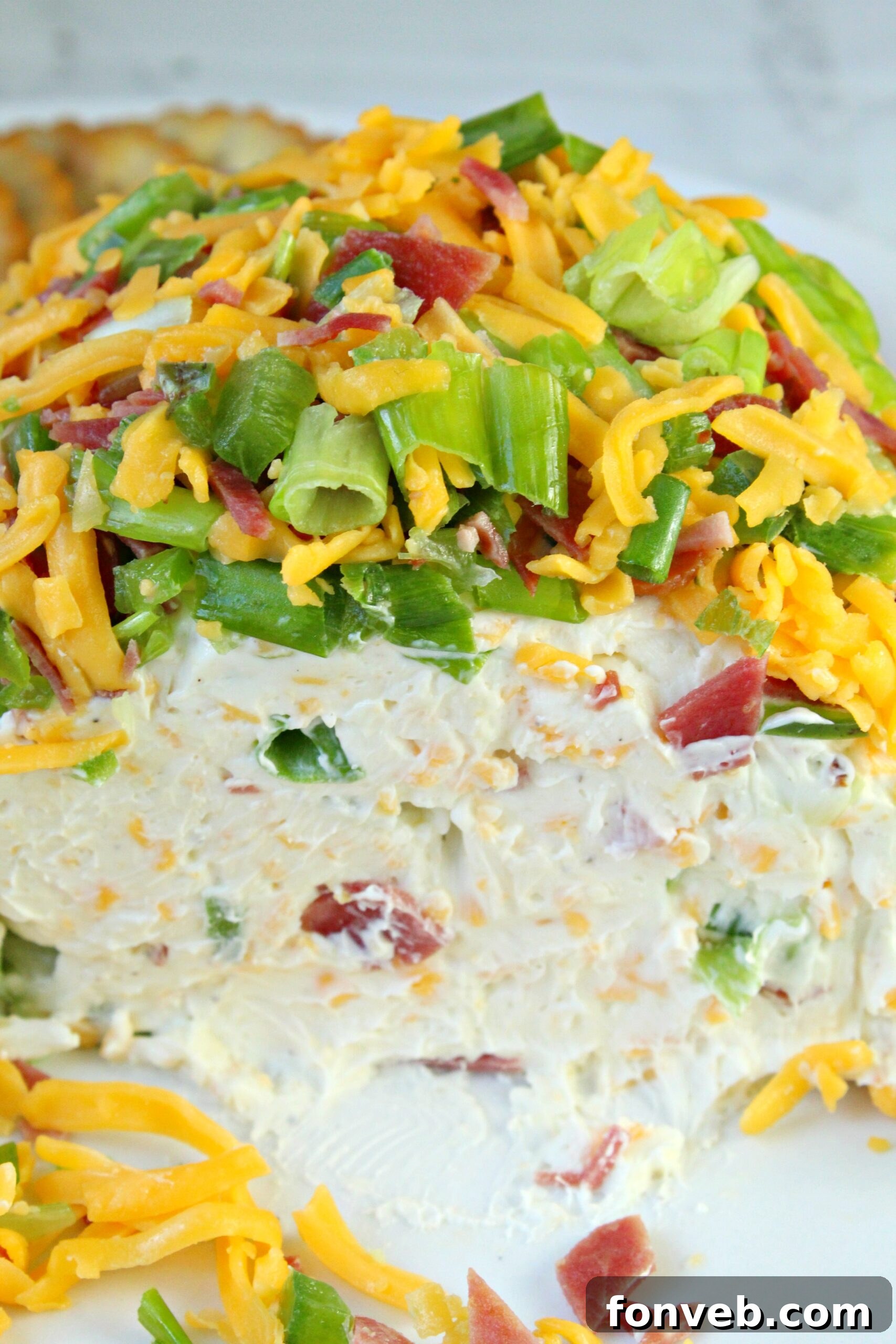 Spicy Cream Cheese Party Ball 7 Jalapeno Popper Cheese Ball being rolled in a savory topping mixture on a cutting board