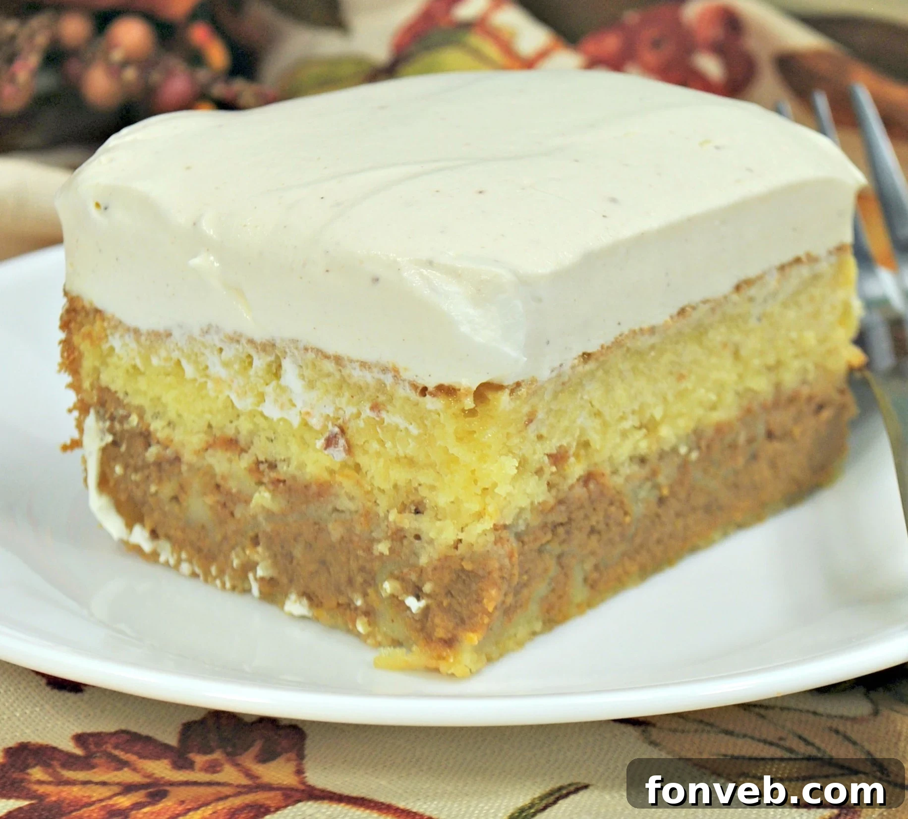 Enchanted Pumpkin Dream Cake 2 A slice of Pumpkin Magic Cake with creamy vanilla frosting on a plate, ready to be enjoyed.