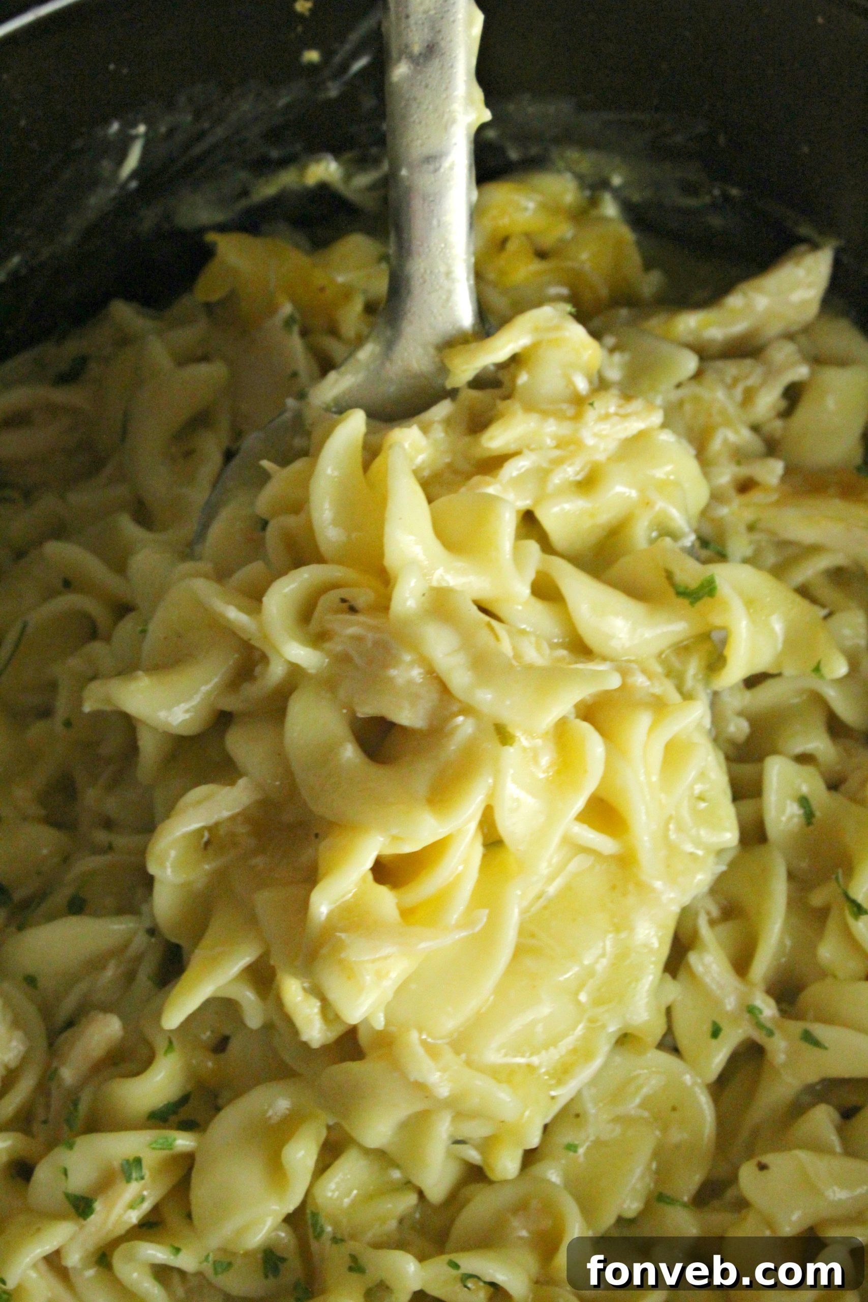 Slow Cooker Chicken and Noodles in a stoneware slow cooker, with a focus on the rich, golden hue of the sauce.