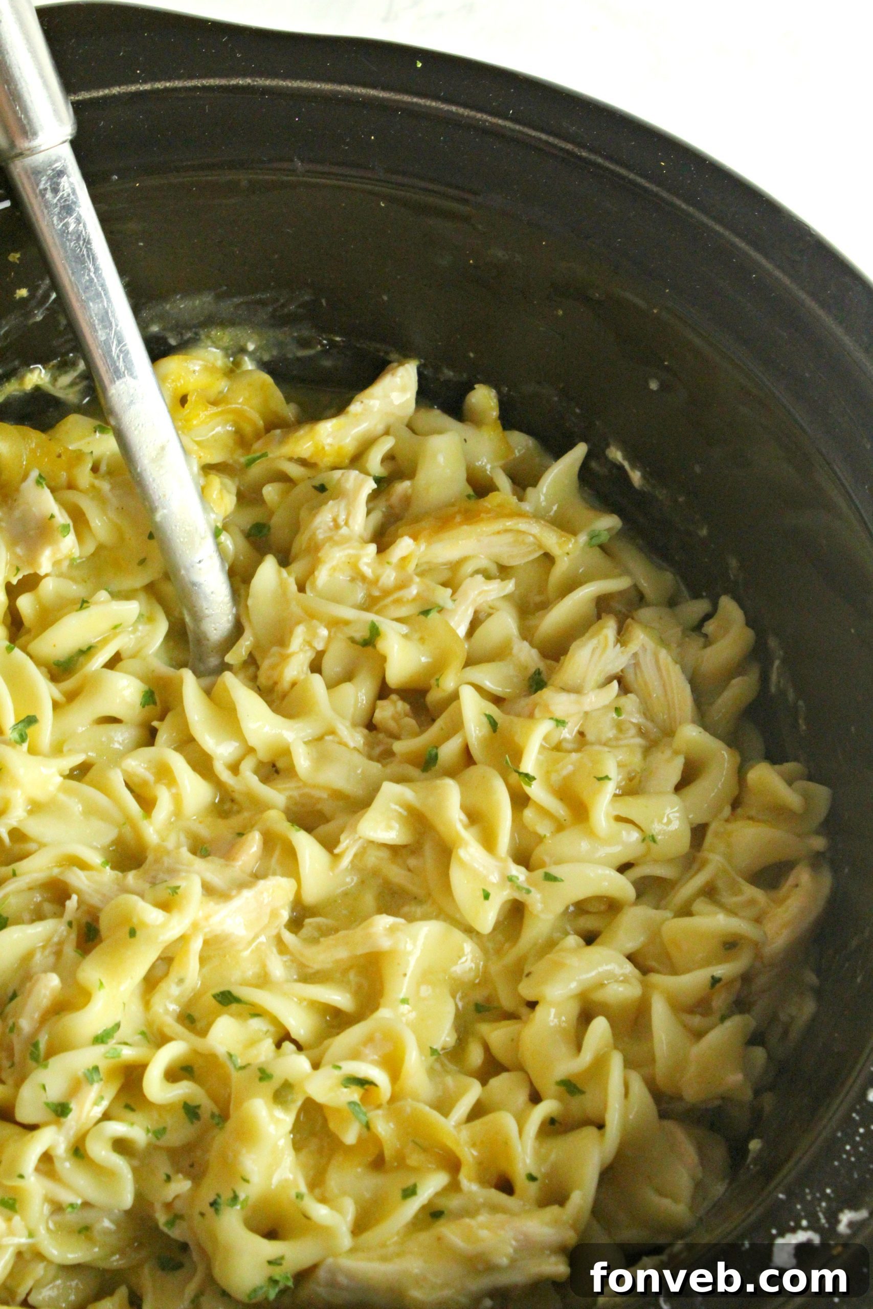 Slow Cooker Chicken and Noodles simmering in a slow cooker, ready to be served.