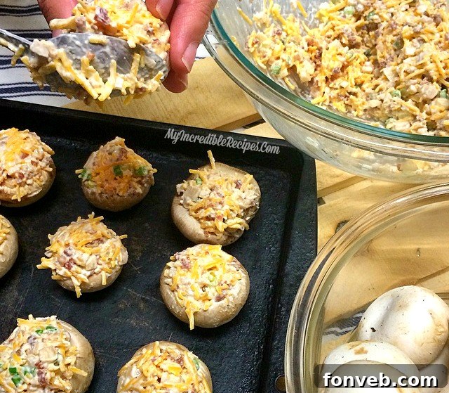 Stuffed mushrooms baking in the oven, with the cheese and bacon filling bubbling and turning golden brown.