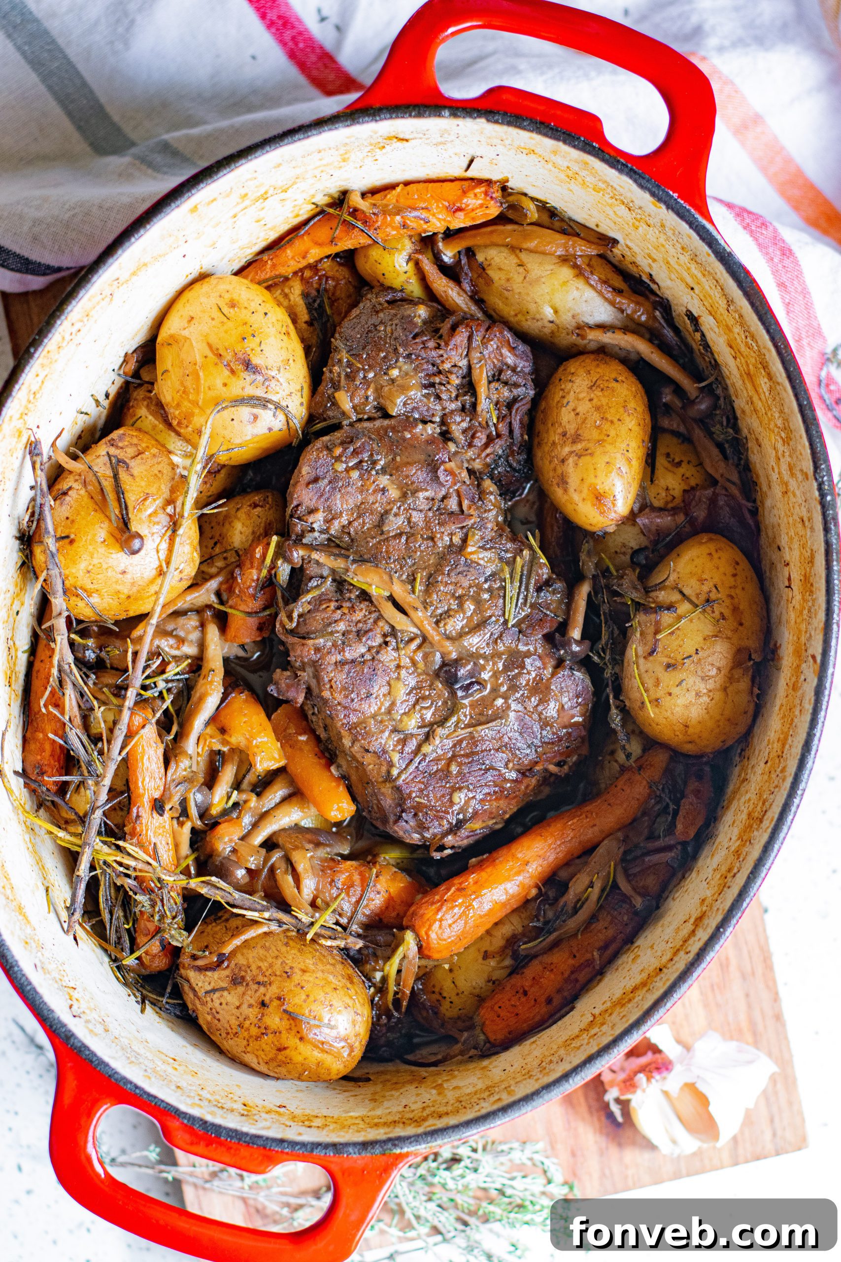 A generous serving of pot roast with potatoes, mushrooms, and carrots on a plate.