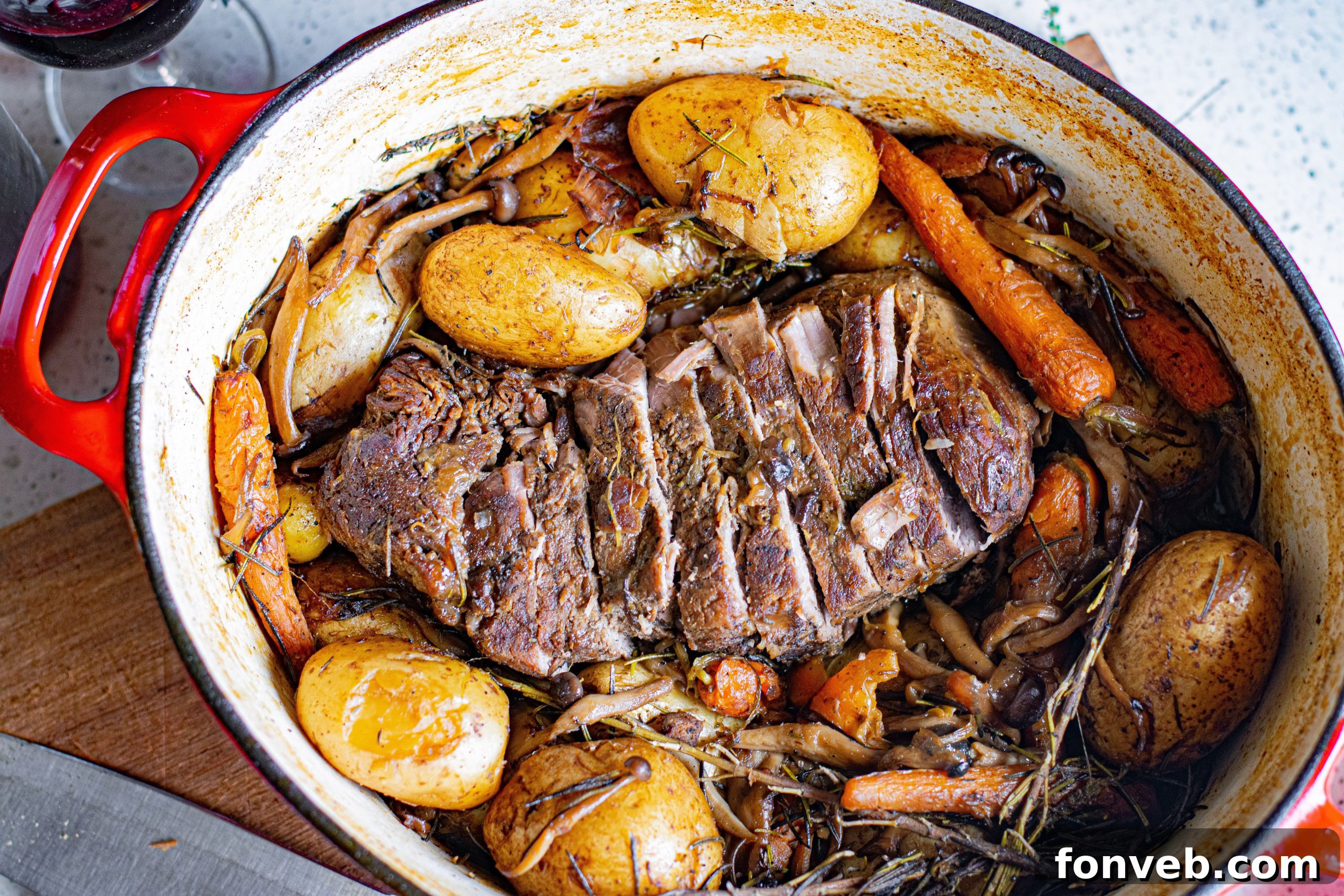A slow-cooked pot roast being pulled apart with forks, showing its tender texture.