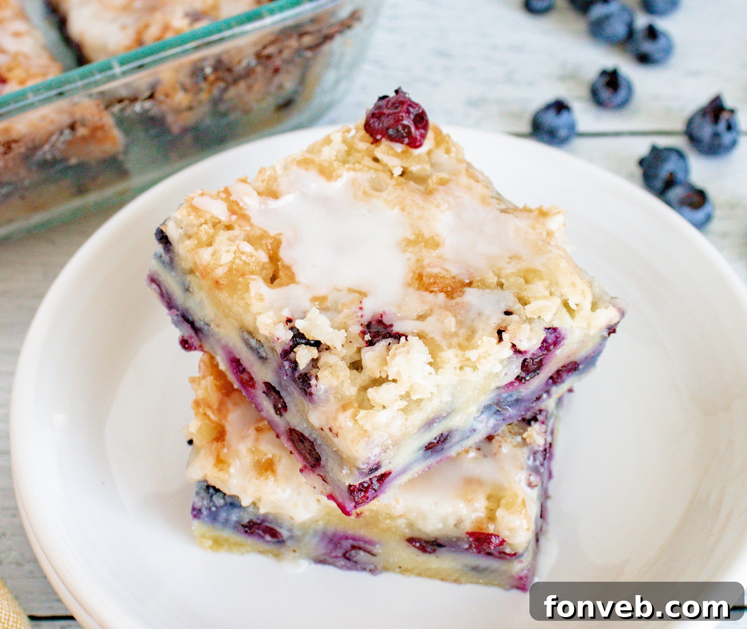 Blueberry Muffin Crumble Cake with Vanilla Drizzle 4 Slice of blueberry muffin cake served with a hot beverage in the morning.