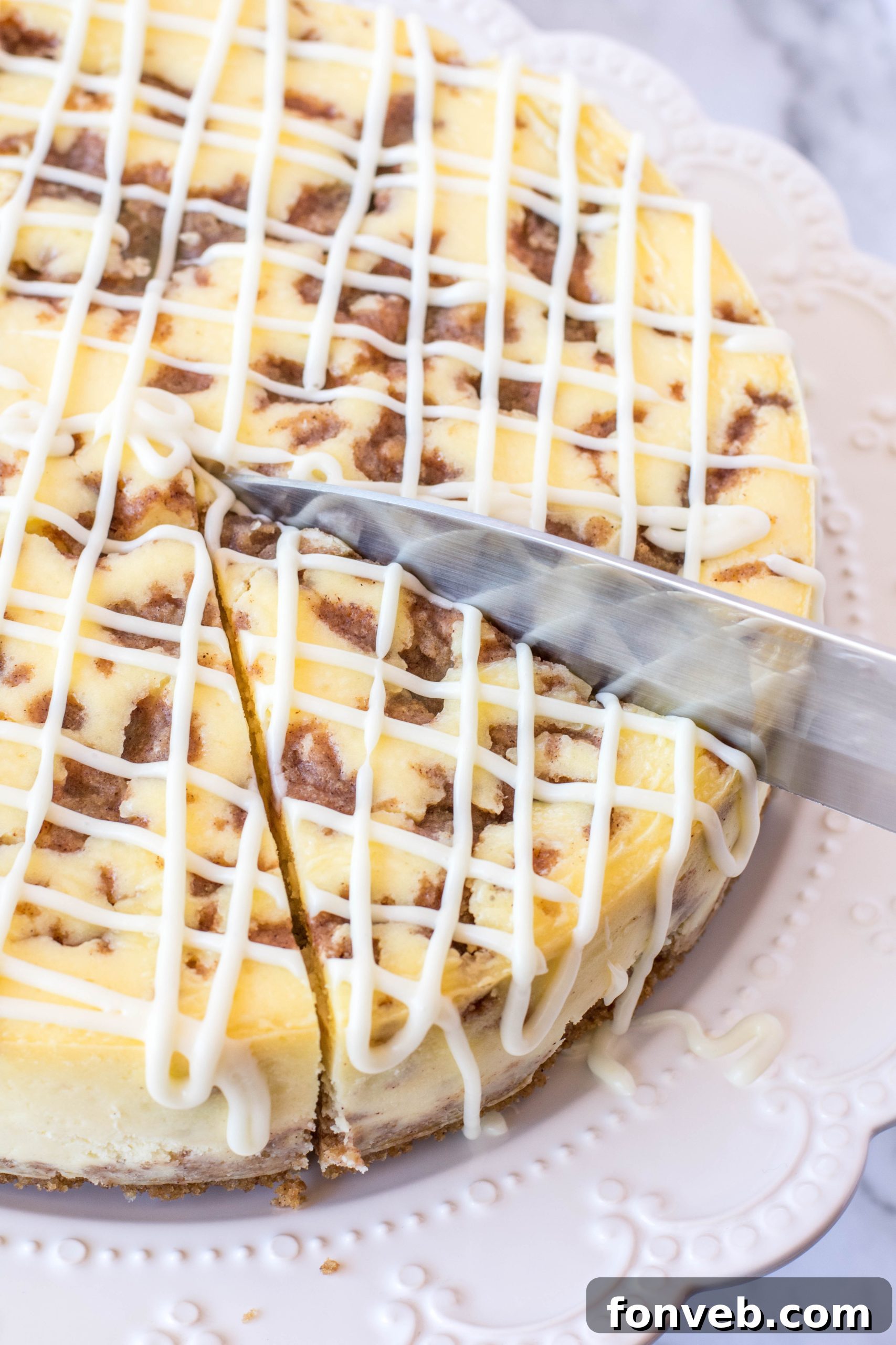 Close-up of a whole Cinnamon Roll Cheesecake, ready to be sliced, showcasing its inviting golden-brown crust and smooth topping.