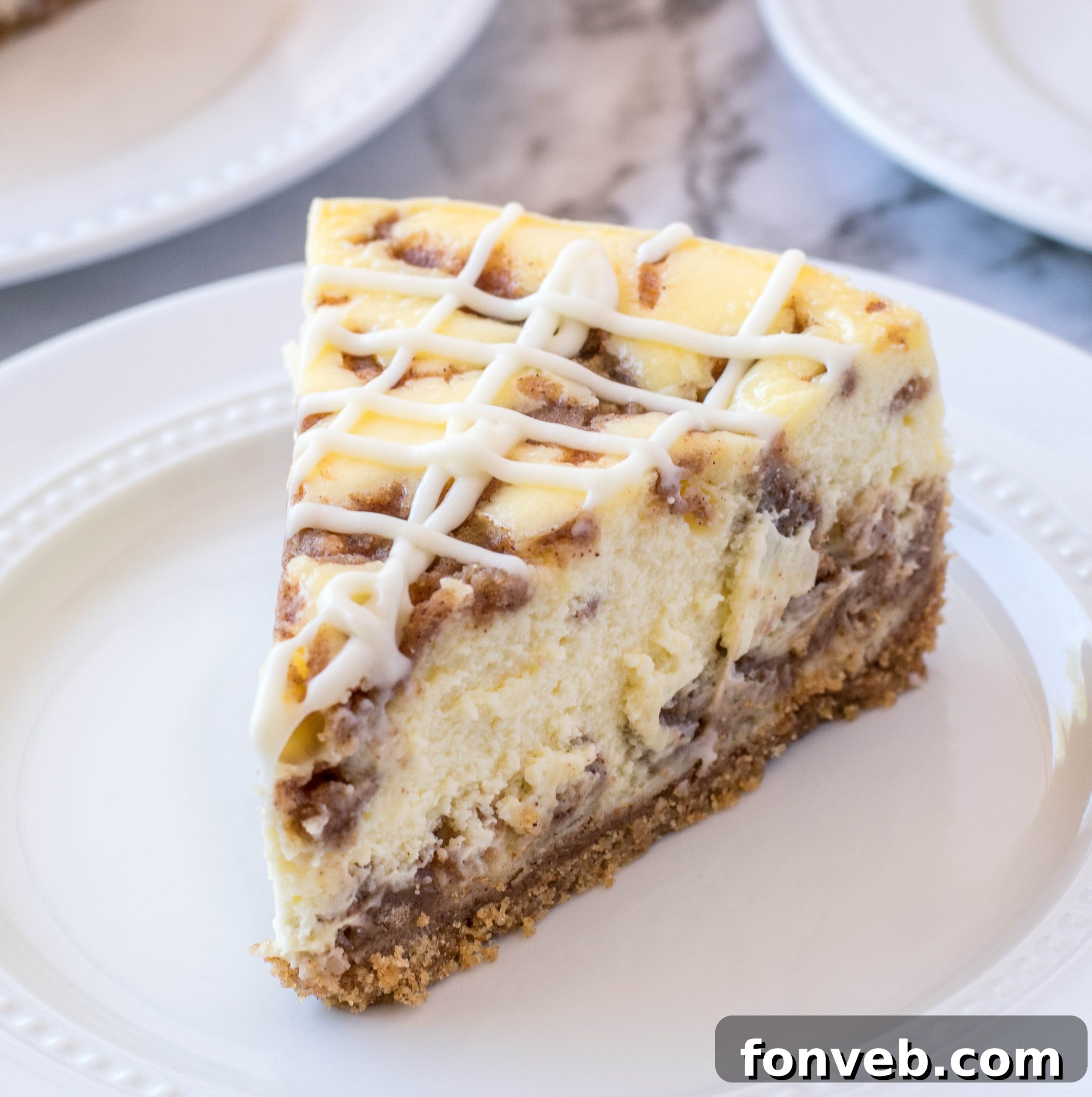 A close-up view of a freshly cut slice of Cinnamon Roll Cheesecake, highlighting the layers and rich texture.