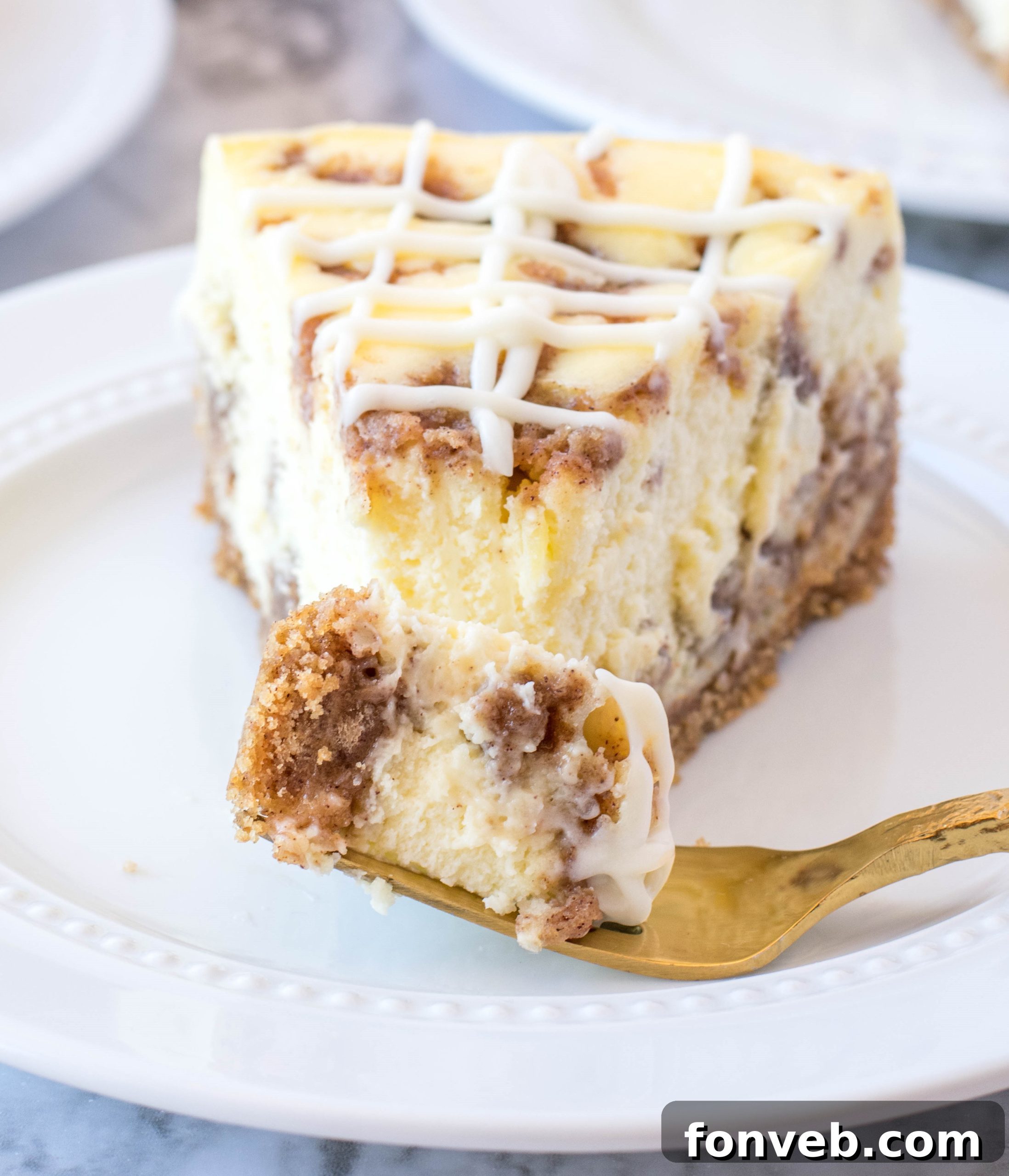 An overhead shot of a full Cinnamon Roll Cheesecake with a delicate dusting of cinnamon, invitingly presented.