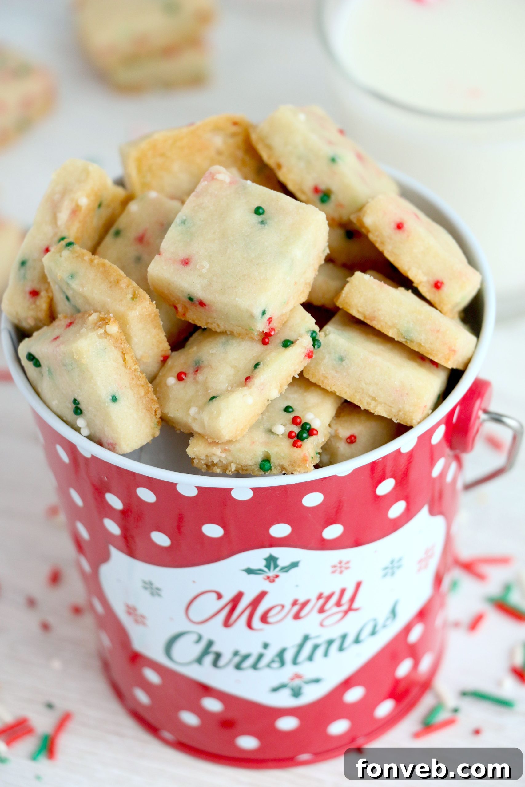 Four Ingredient Festive Shortbread Bites 5 A festive holiday scene with more Christmas Shortbread Cookie Bites on a decorative plate, ready to be enjoyed.