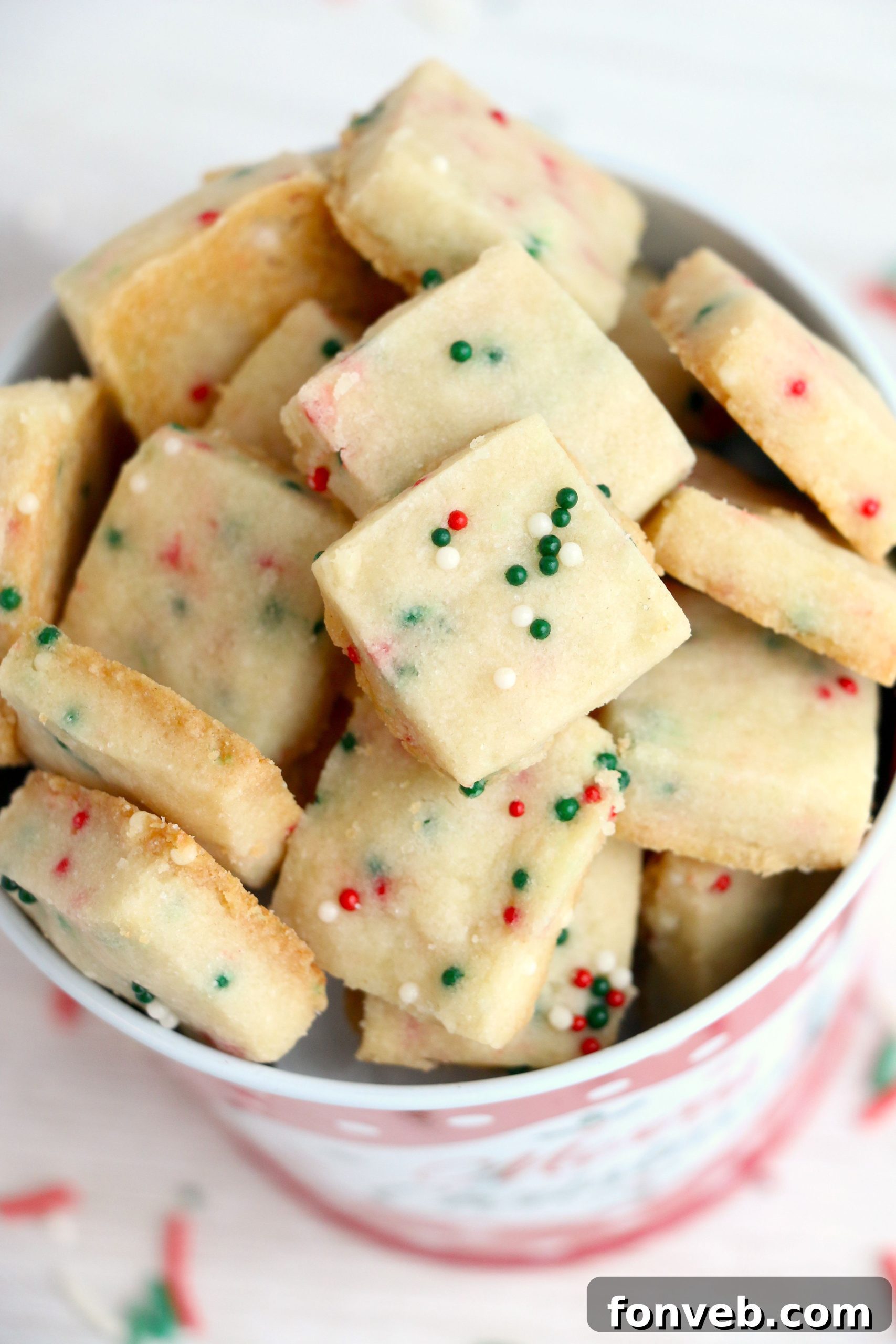Four Ingredient Festive Shortbread Bites 7 A beautiful, artfully arranged display of many Christmas Shortbread Cookie Bites, perfect for a holiday centerpiece.