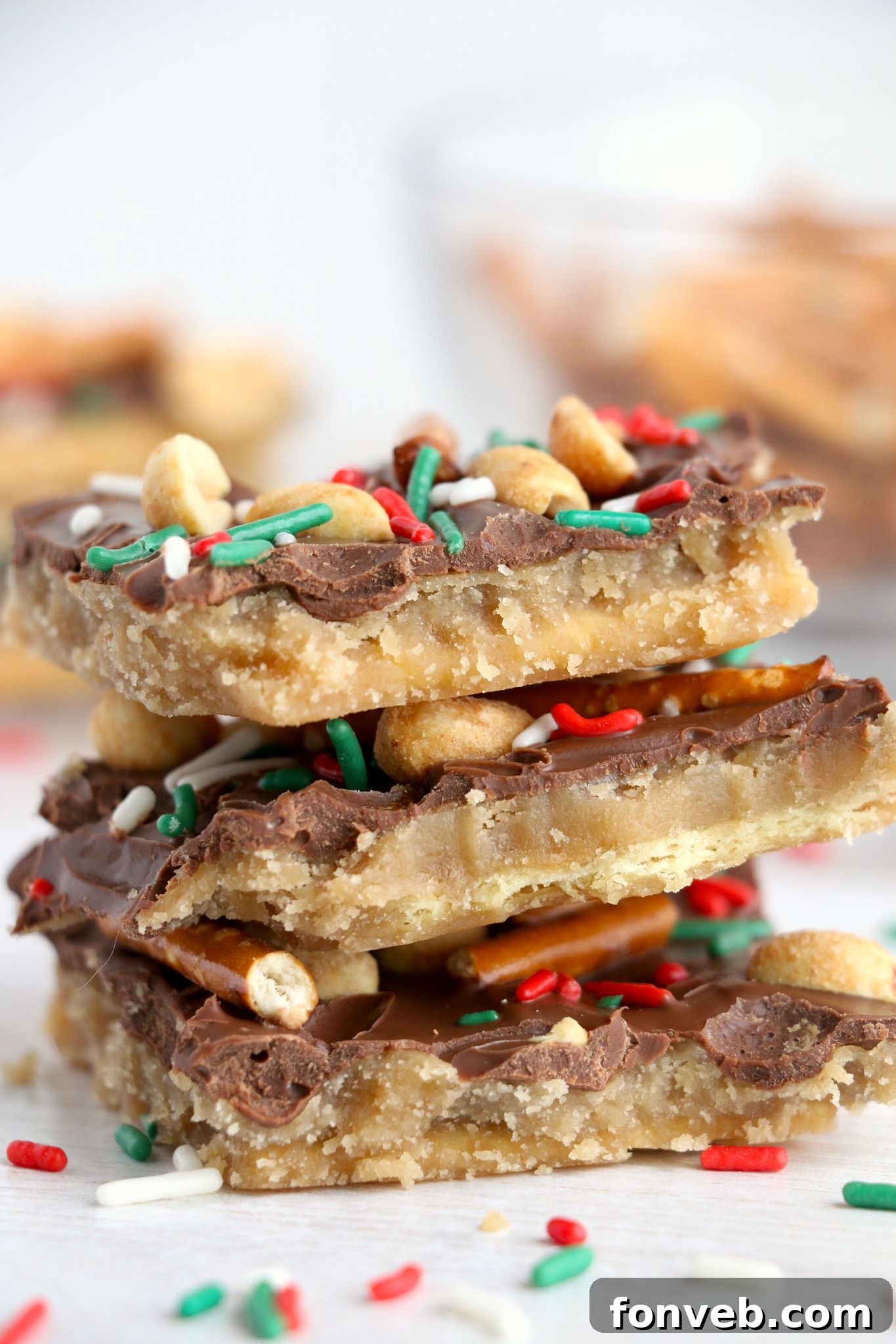 Toffee Pretzel Peanut Bark 5 Hand breaking a piece of Pretzel Peanut Cracker Toffee, emphasizing the 'crack' texture.
