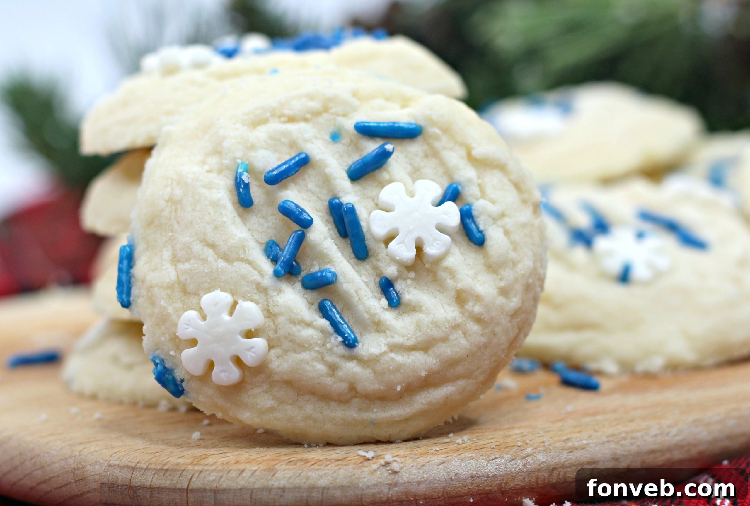 Assorted whipped shortbread cookies, some with sprinkles, others plain, on a baking tray.