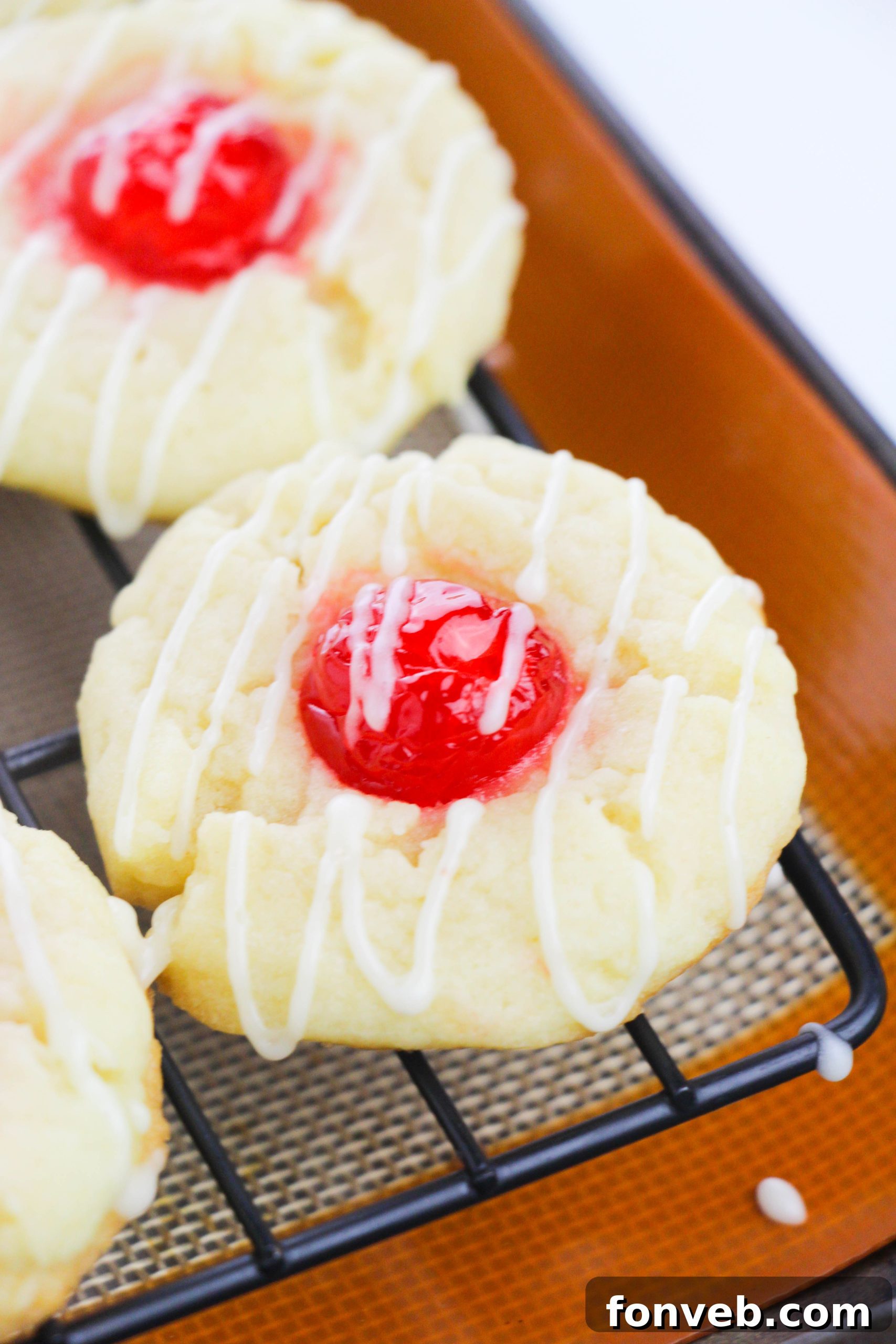 A tray of freshly baked Eggnog Thumbprint Cookies before the icing drizzle, showing their golden edges