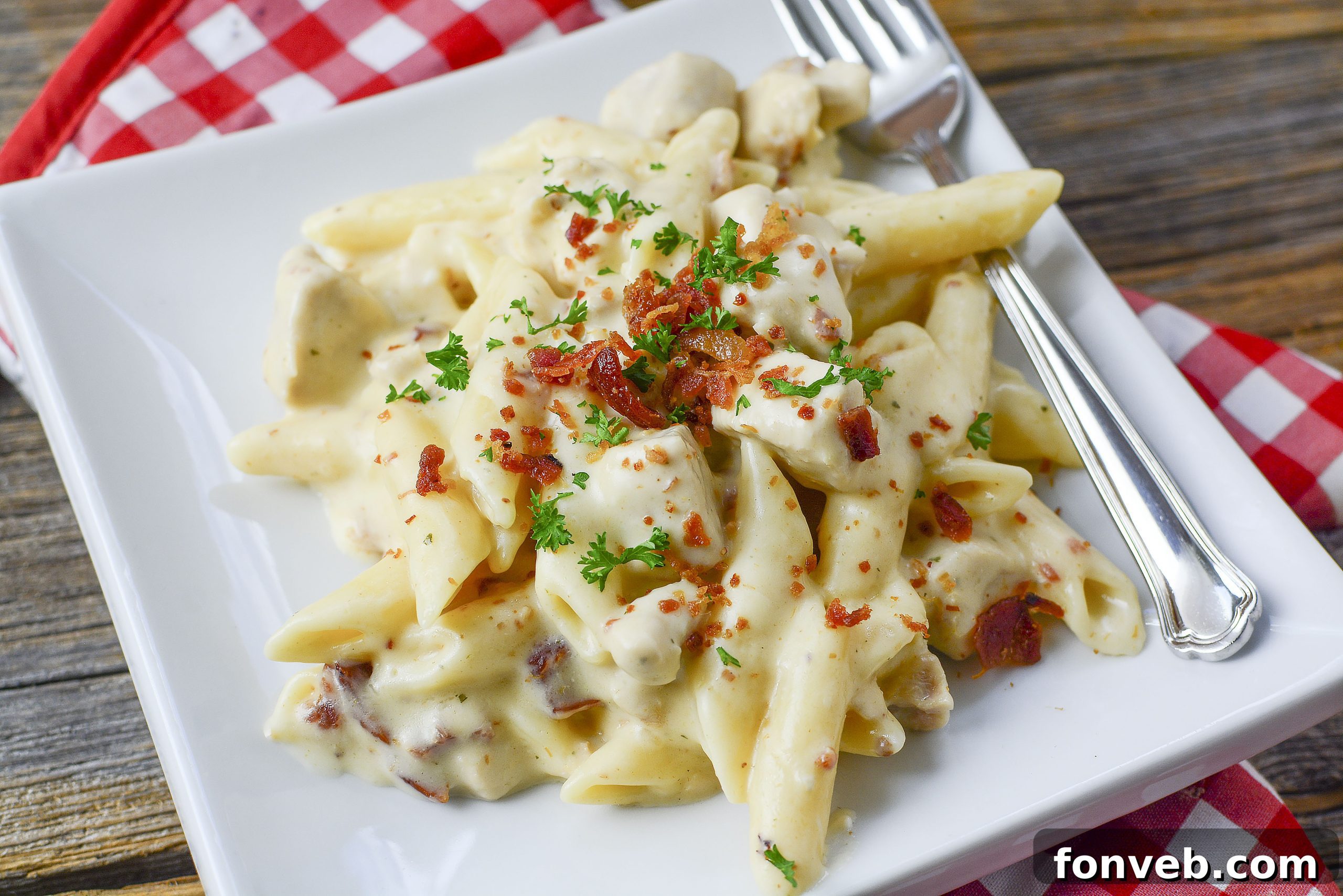 A generous serving of Instant Pot Crack Chicken Pasta in a white bowl, garnished with green herbs.
