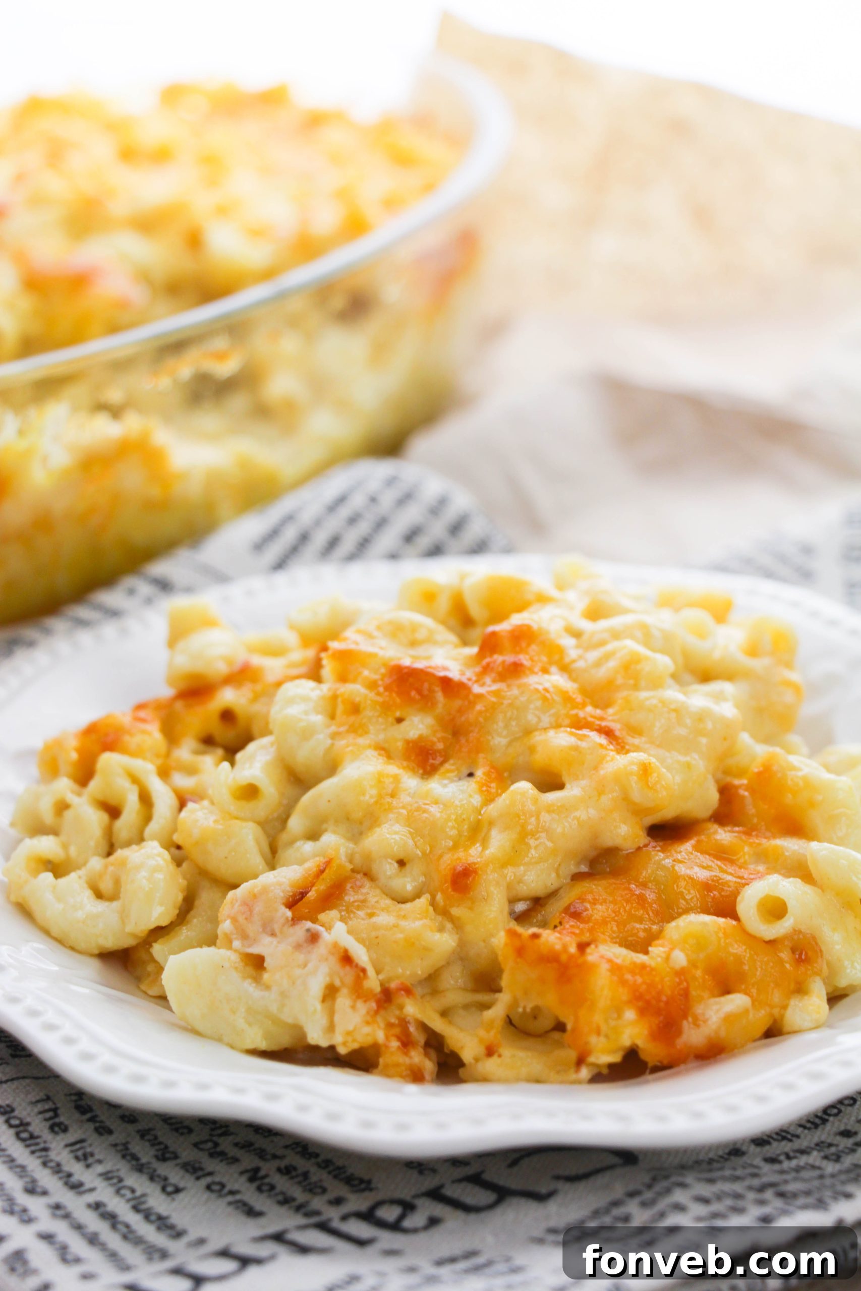 Baked macaroni and cheese with added chopped ham or chicken, illustrating a one-pan meal variation