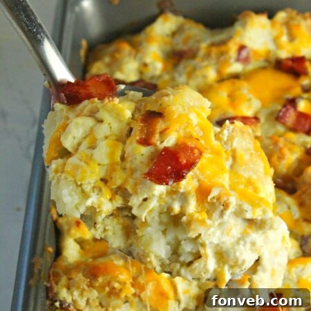 The ultimate Cracked Out Chicken Tater Tot Casserole, garnished and ready to be served from a white baking dish.