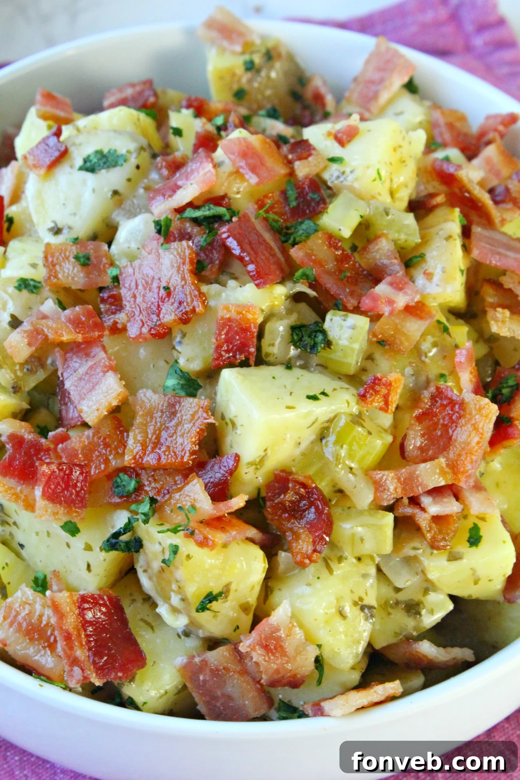 Tangy German Potato Salad 2 Delicious German Potato Salad served in a bowl, garnished with fresh parsley.