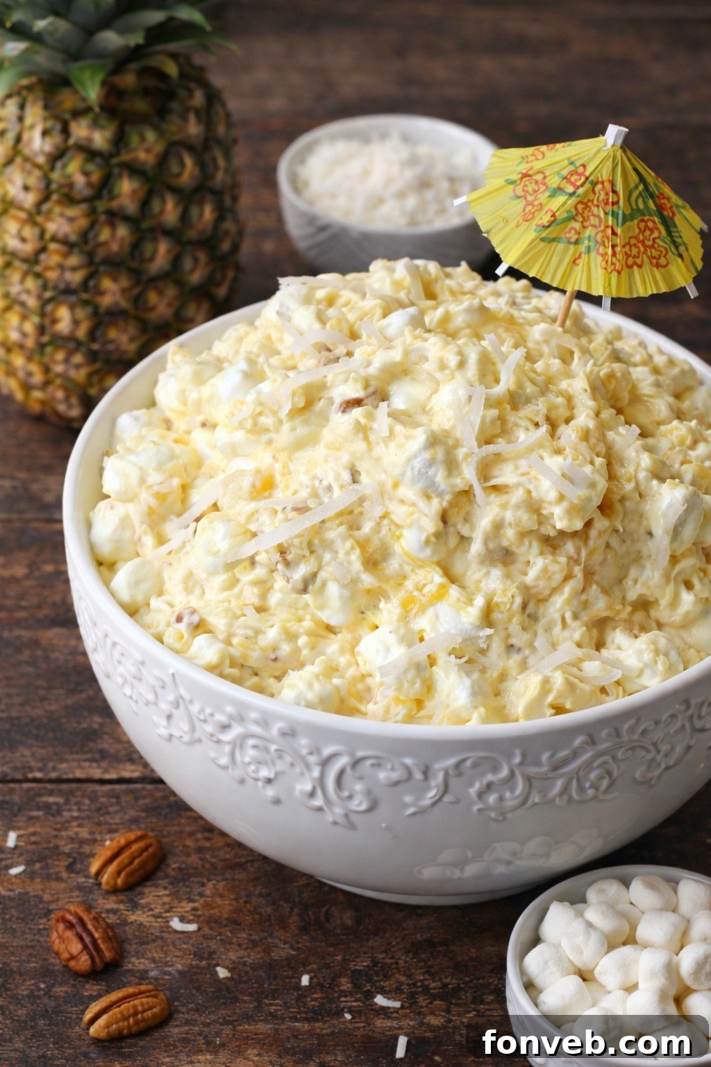 Piña Colada Fluff served in a white bowl with a spoon.