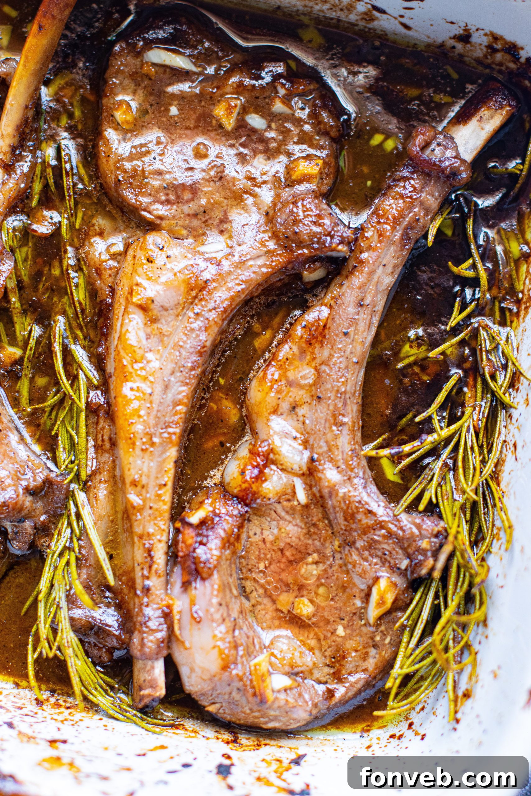 Cooked lamb chops resting in a baking dish, glistening with marinade and ready to be served