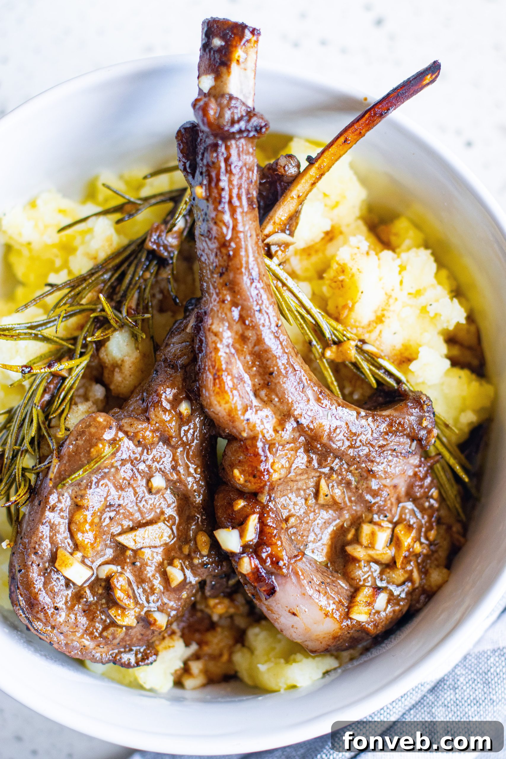 Several cooked lamb chops neatly stacked in an airtight container for refrigeration