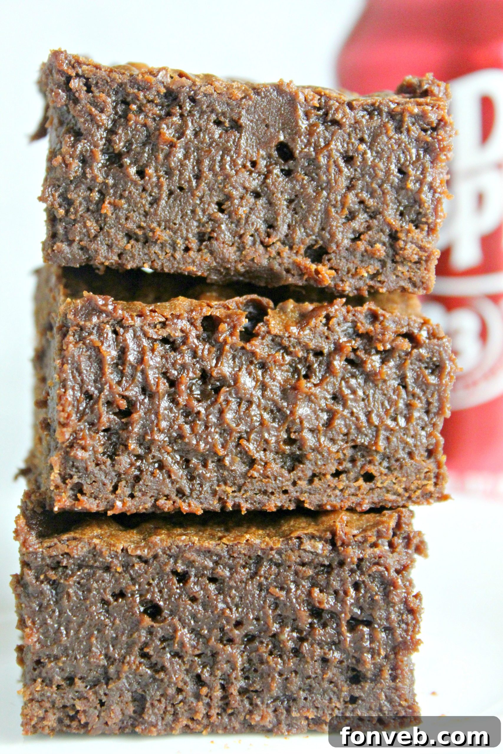 Close-up of a Dr. Pepper brownie with a delicate powdered sugar glaze drizzled over its surface, adding a touch of elegance.