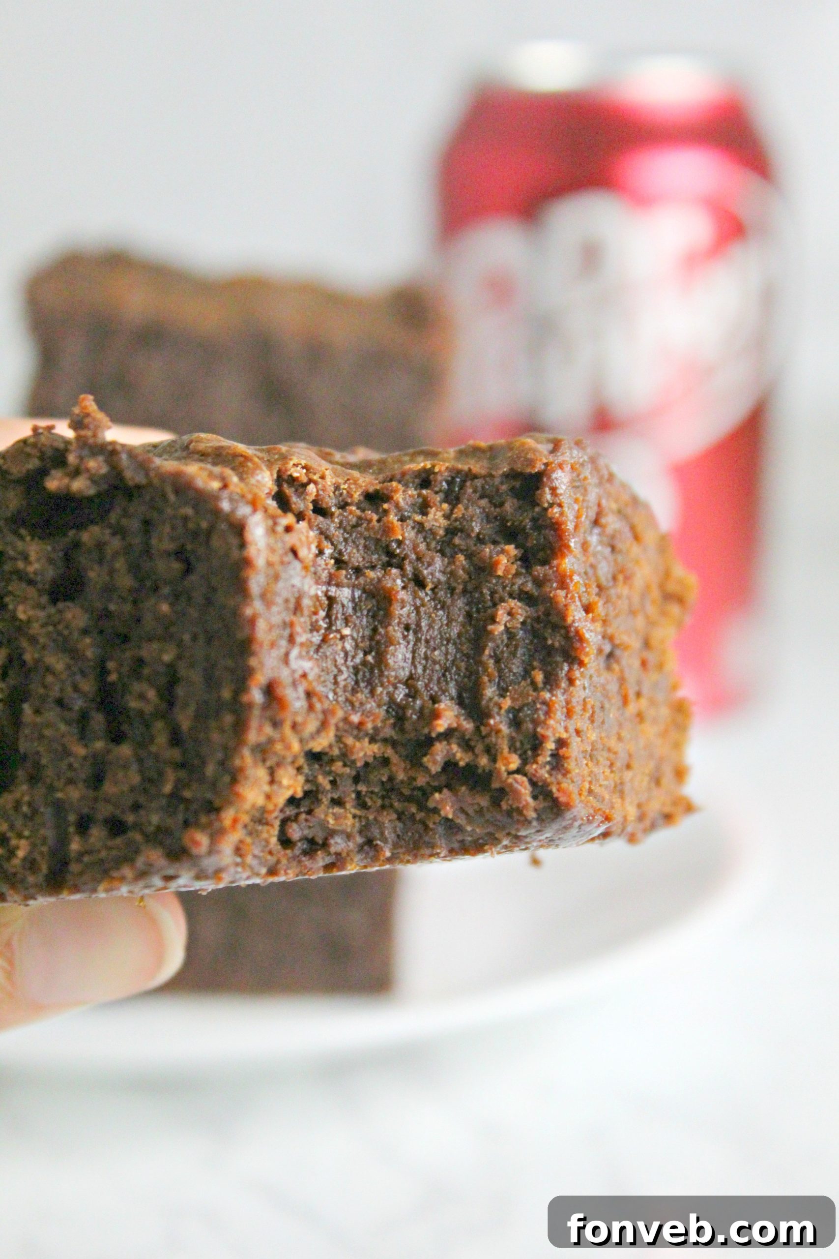 A vibrant display of Dr. Pepper brownies, some topped with a contrasting white frosting, making them look even more appealing for a party.