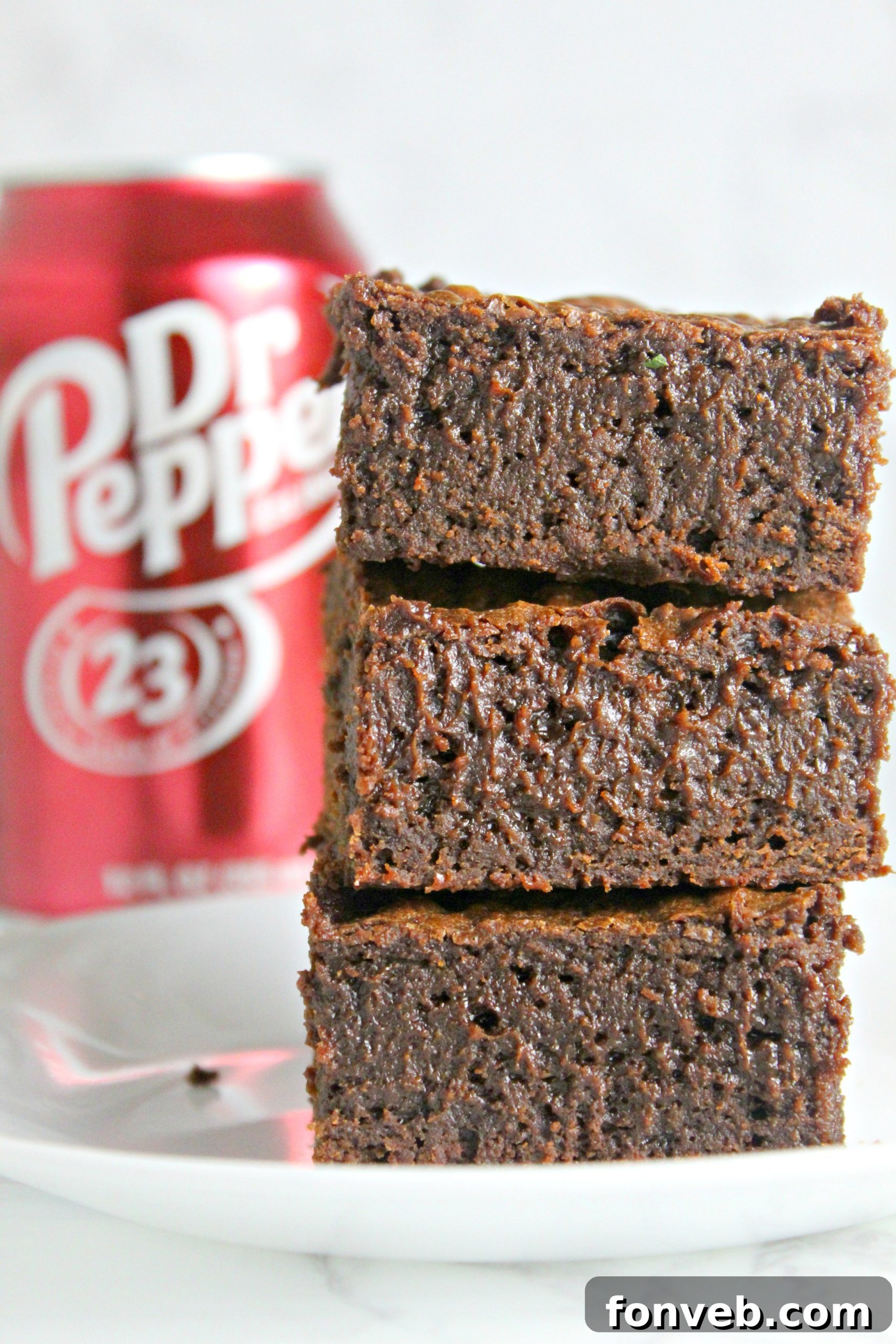 Neatly arranged Dr. Pepper brownie squares in a storage container, ready to be covered and kept fresh.