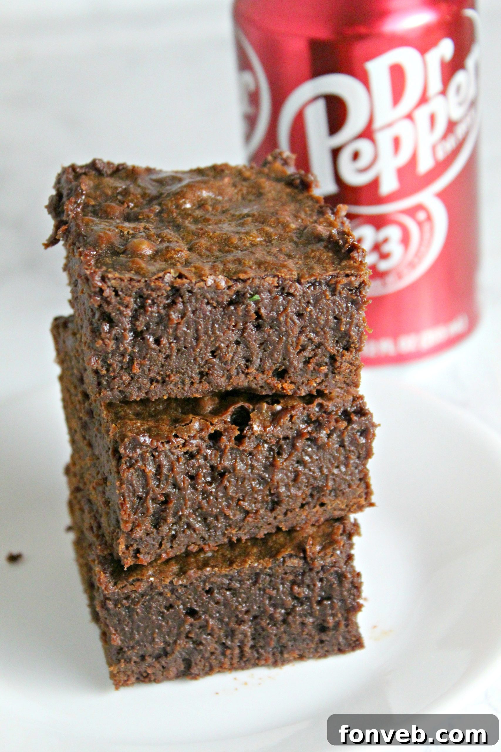 A stack of individually wrapped Dr. Pepper brownies, ready for freezing, demonstrating a practical storage method.